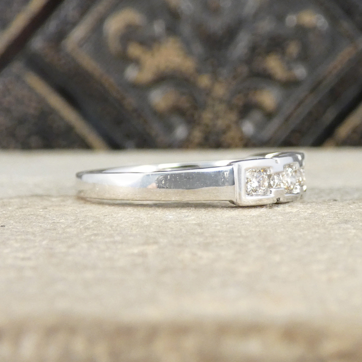 White Gold ring with small diamonds on a textured surface