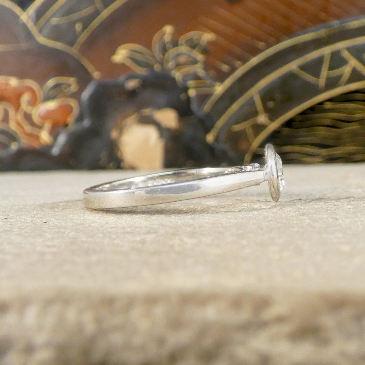 Side profile or bezel set diamond solitaire ring, showing wedfit design and plain polished band.