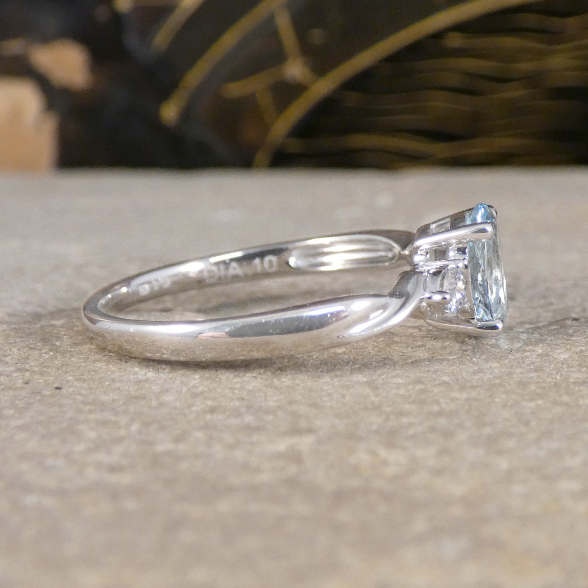 Side view of Modern Oval Cut Aquamarine and Brilliant Cut Diamond Three Stone in Platinum.