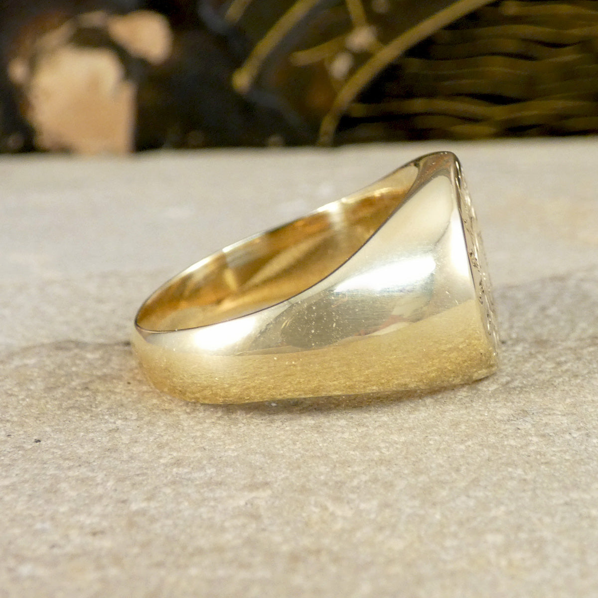 A solid yellow gold signet ring with a face engraved with a sun and moon