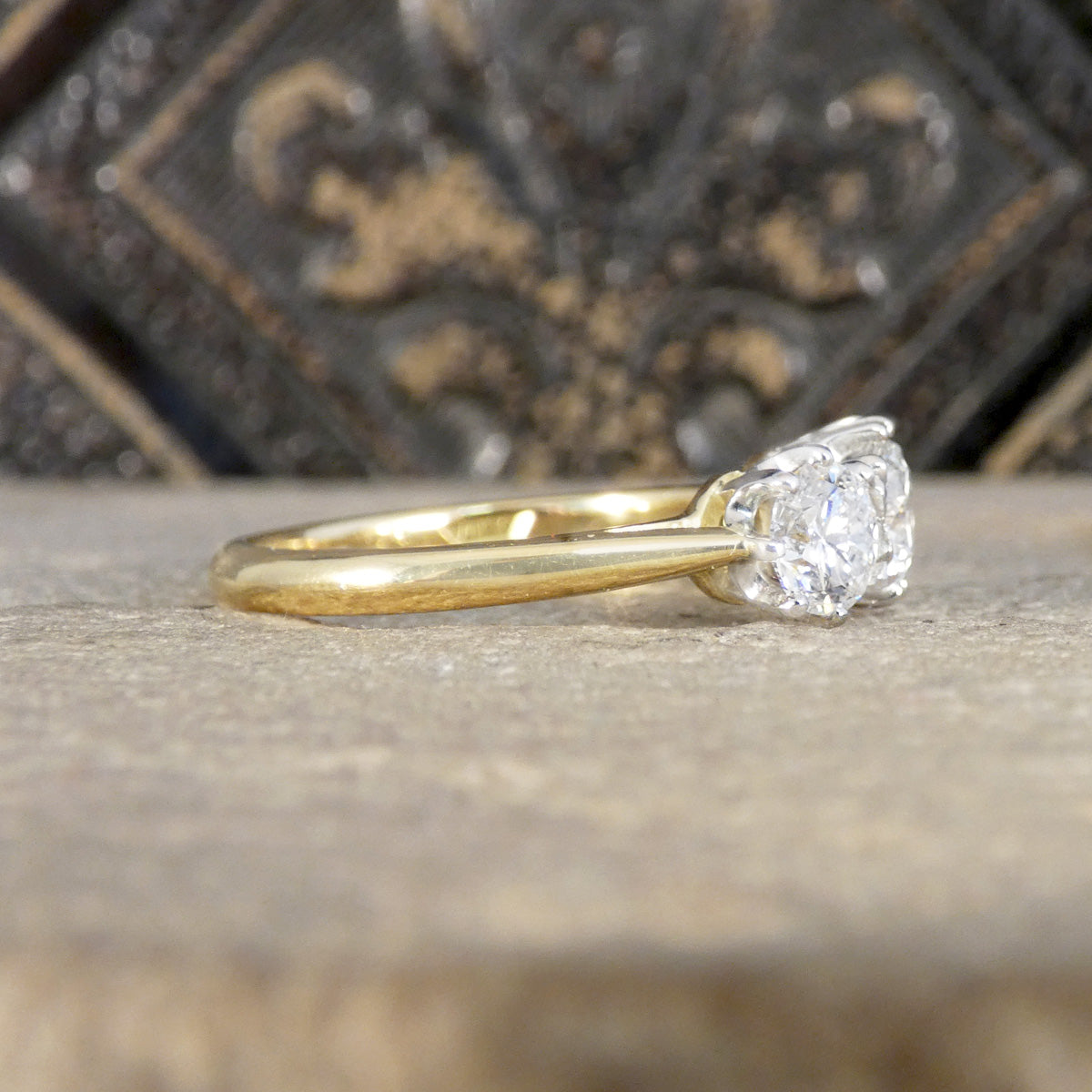 Gold ring with a diamond on a textured surface
