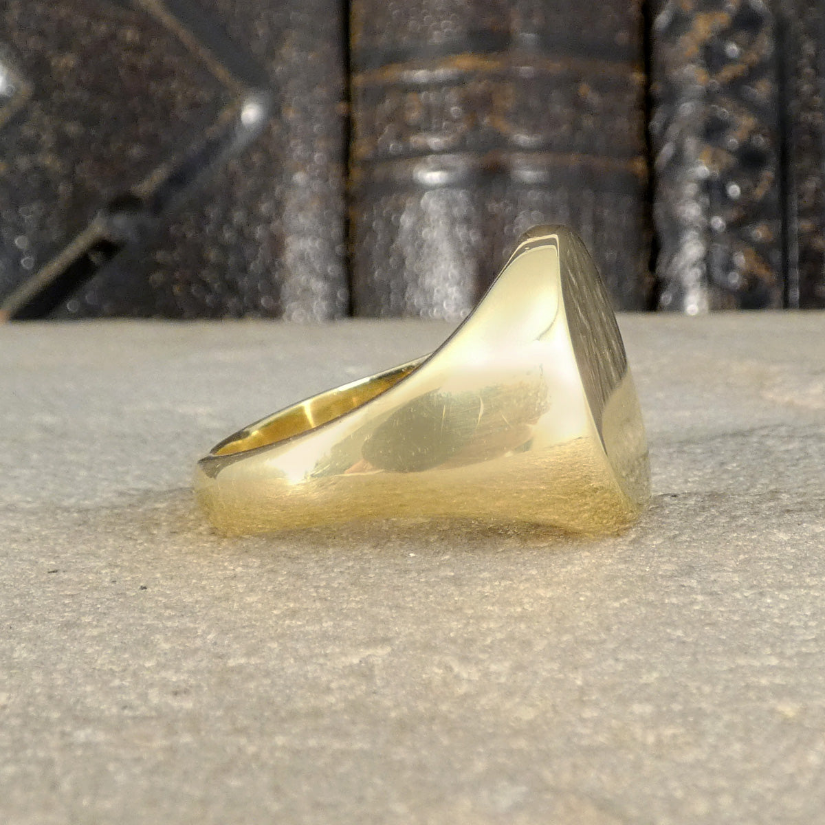 Gold ring on a textured surface with a dark, patterned background
