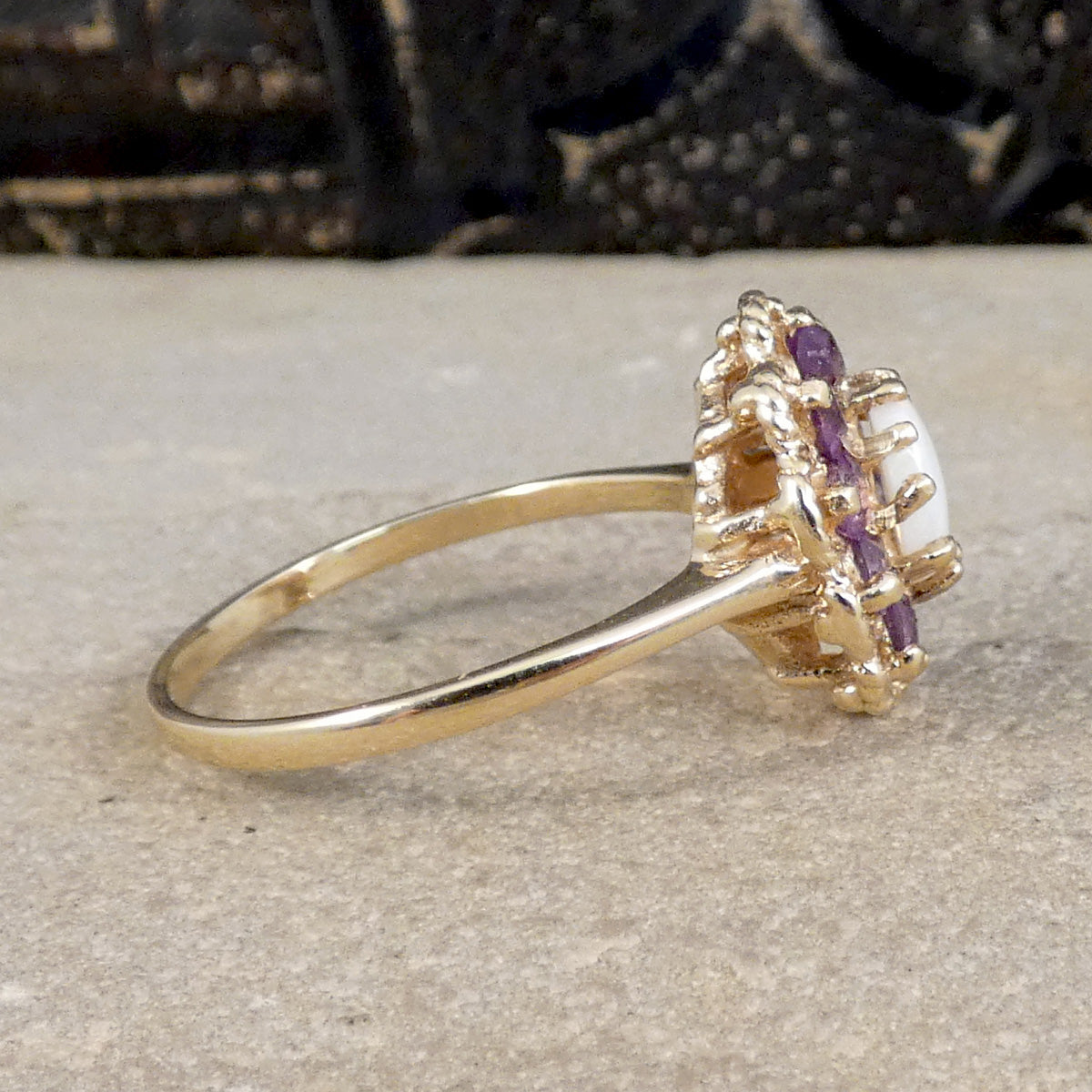 Side view of 9ct yellow gold cluster ring with plain polished band and claw set stones.