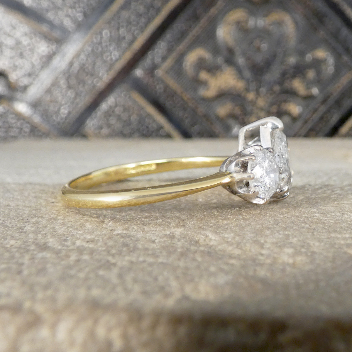 Gold ring with a diamond on a textured surface