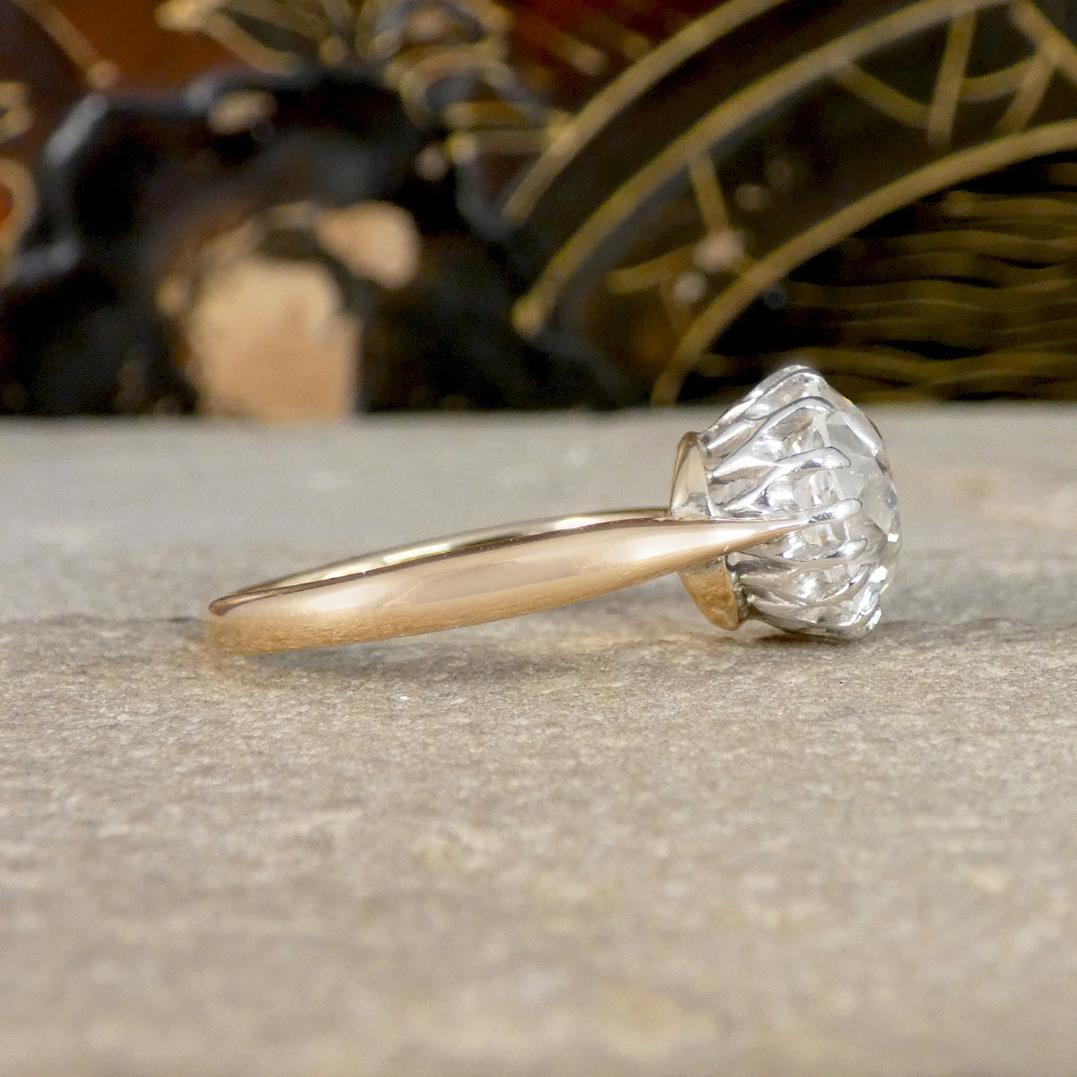 Side view of an Old Cushion shaped Mine cut diamond solitaire ring with a yellow gold band.