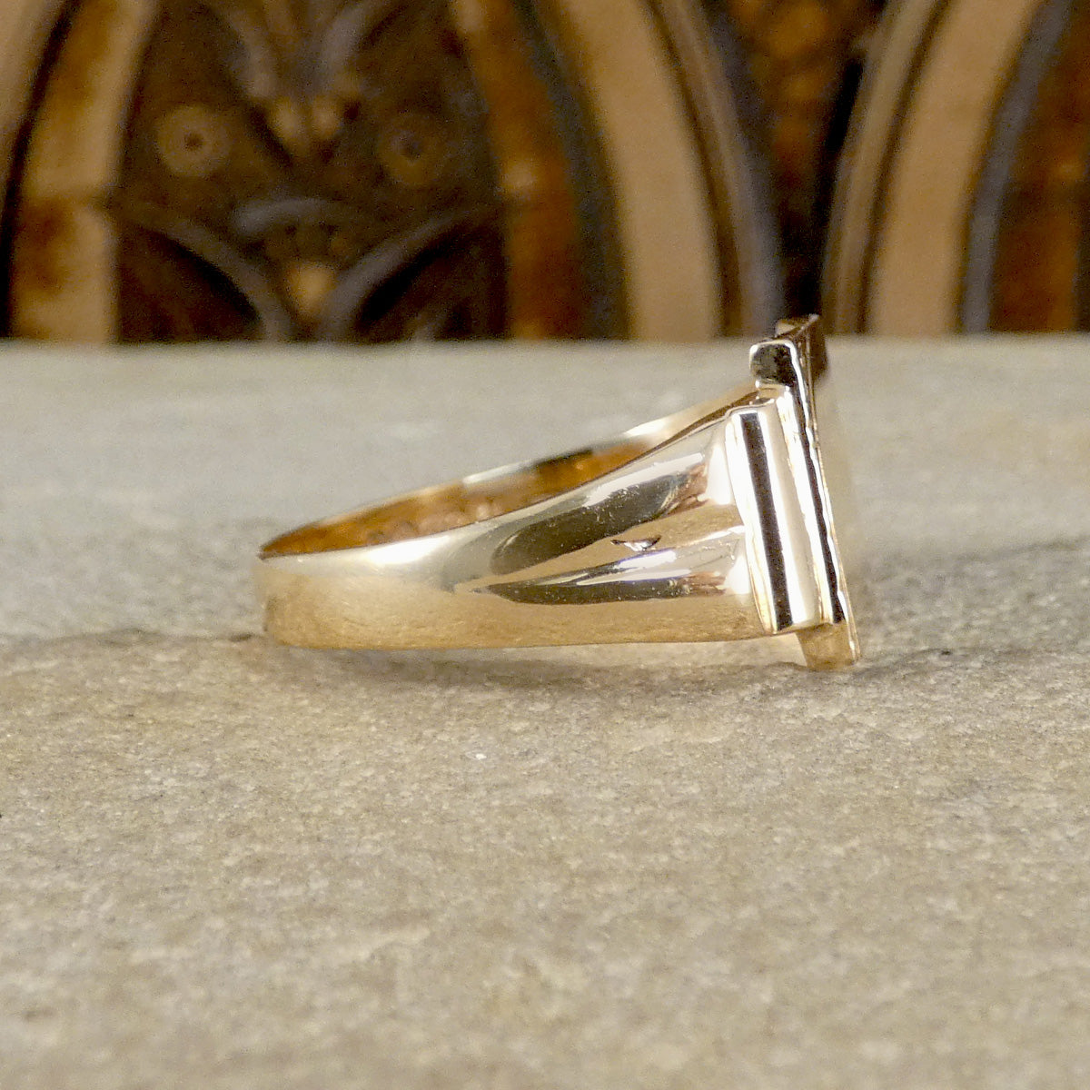 Gold ring on a textured surface with a blurred background