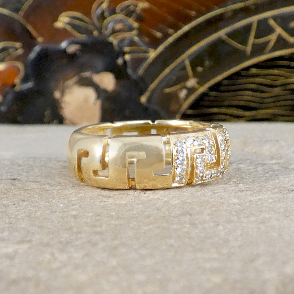 Gold ring with diamond accents on a textured surface