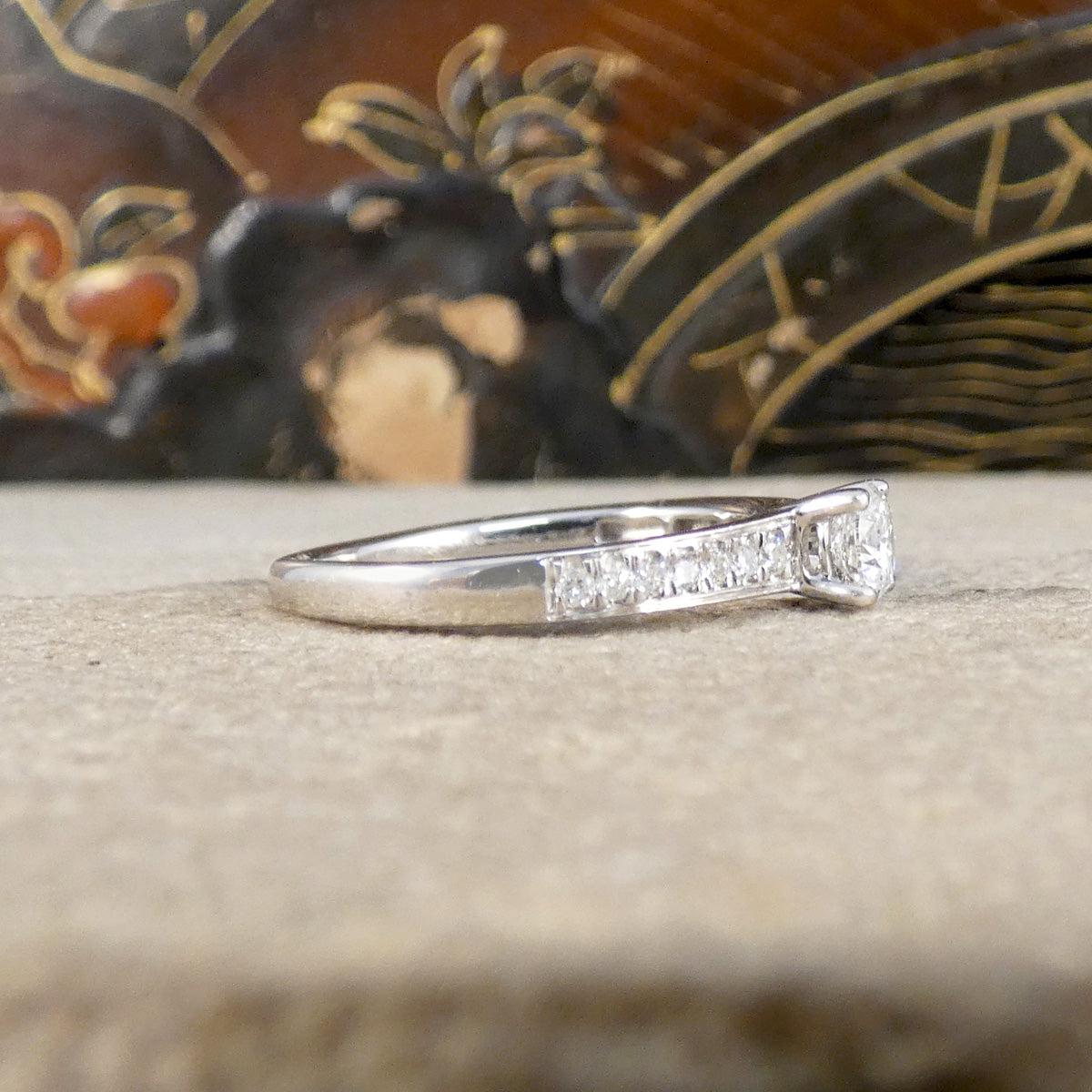 Silver ring with small diamonds on a textured surface