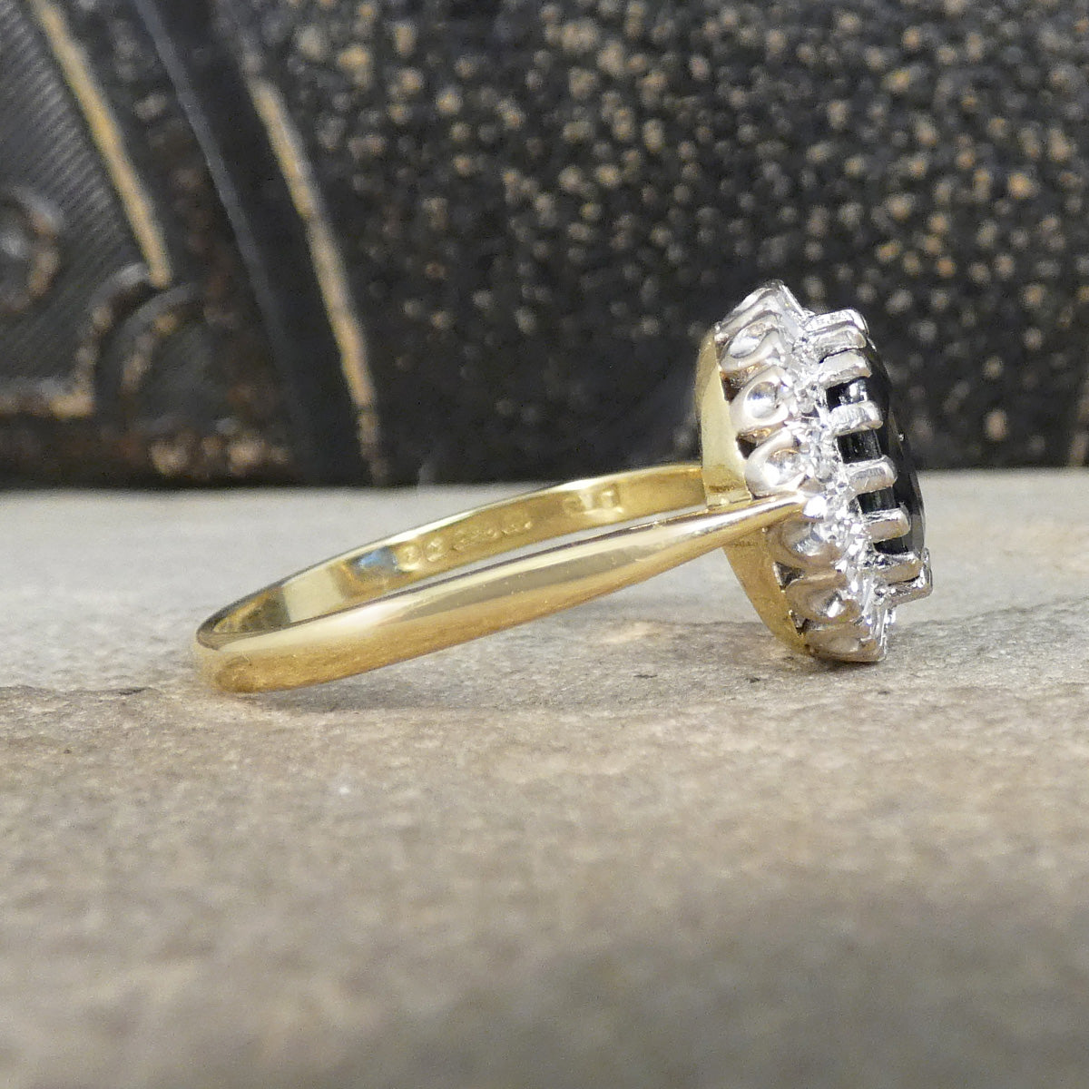 Gold ring with a diamond on a textured surface