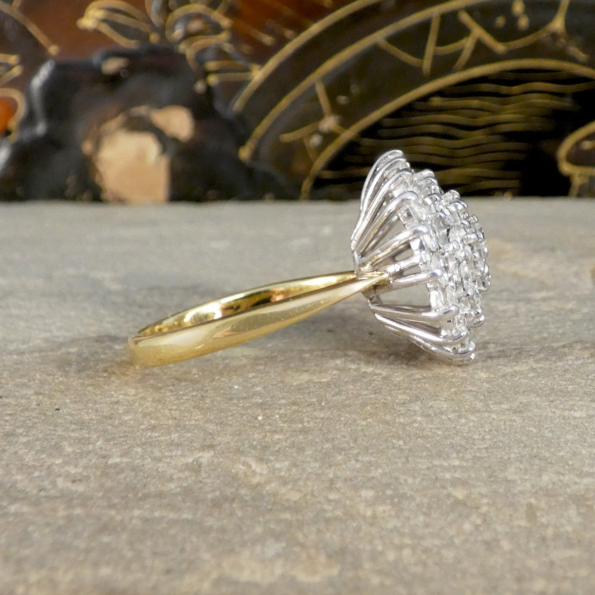 Gold ring with a diamond fan-shaped setting on a textured surface