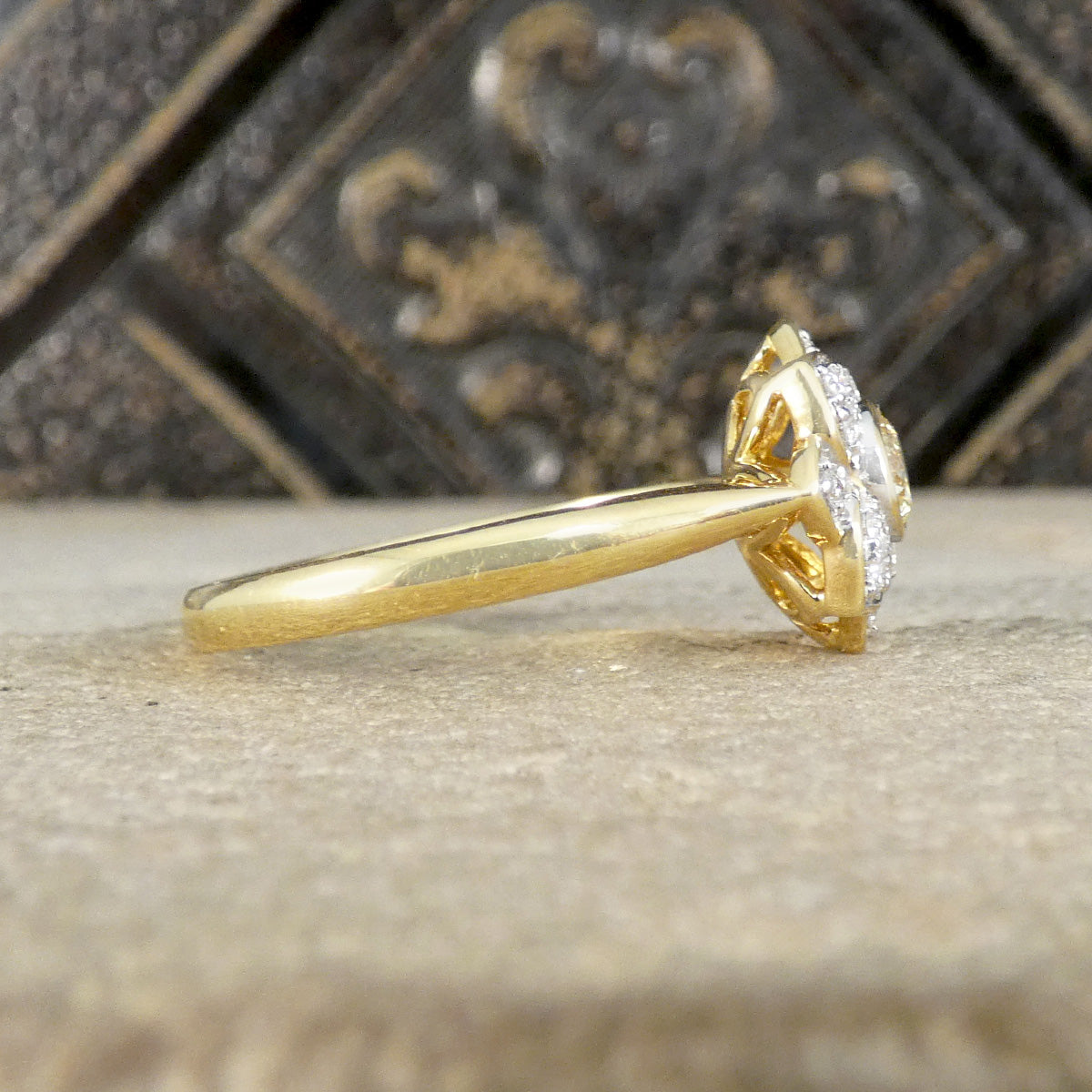 Gold ring with a diamond on a textured surface
