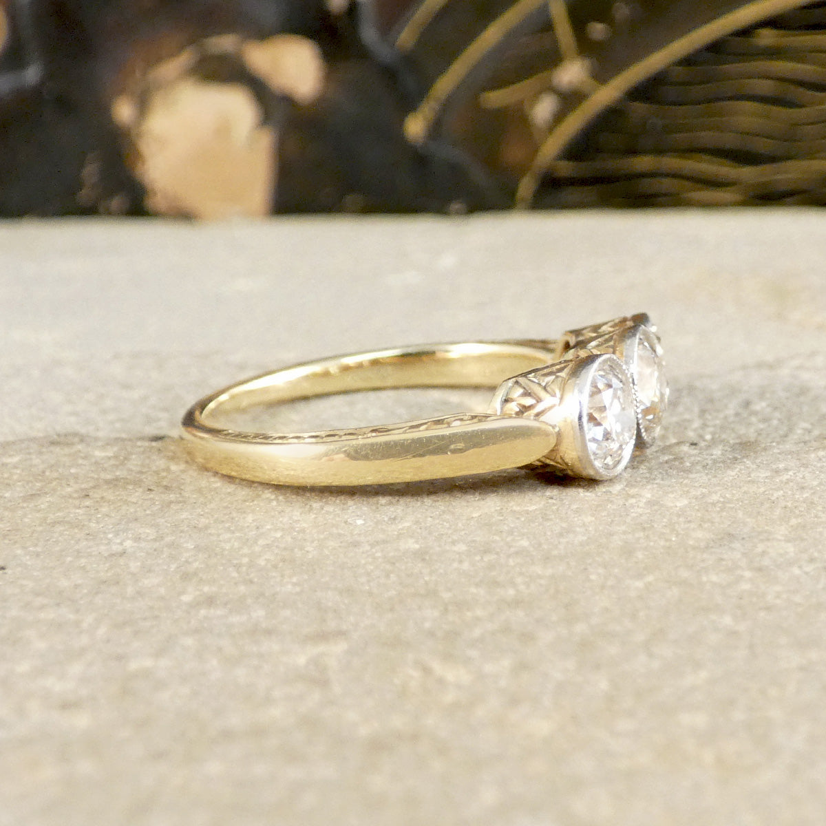 Gold vintage ring with two diamonds on a textured surface