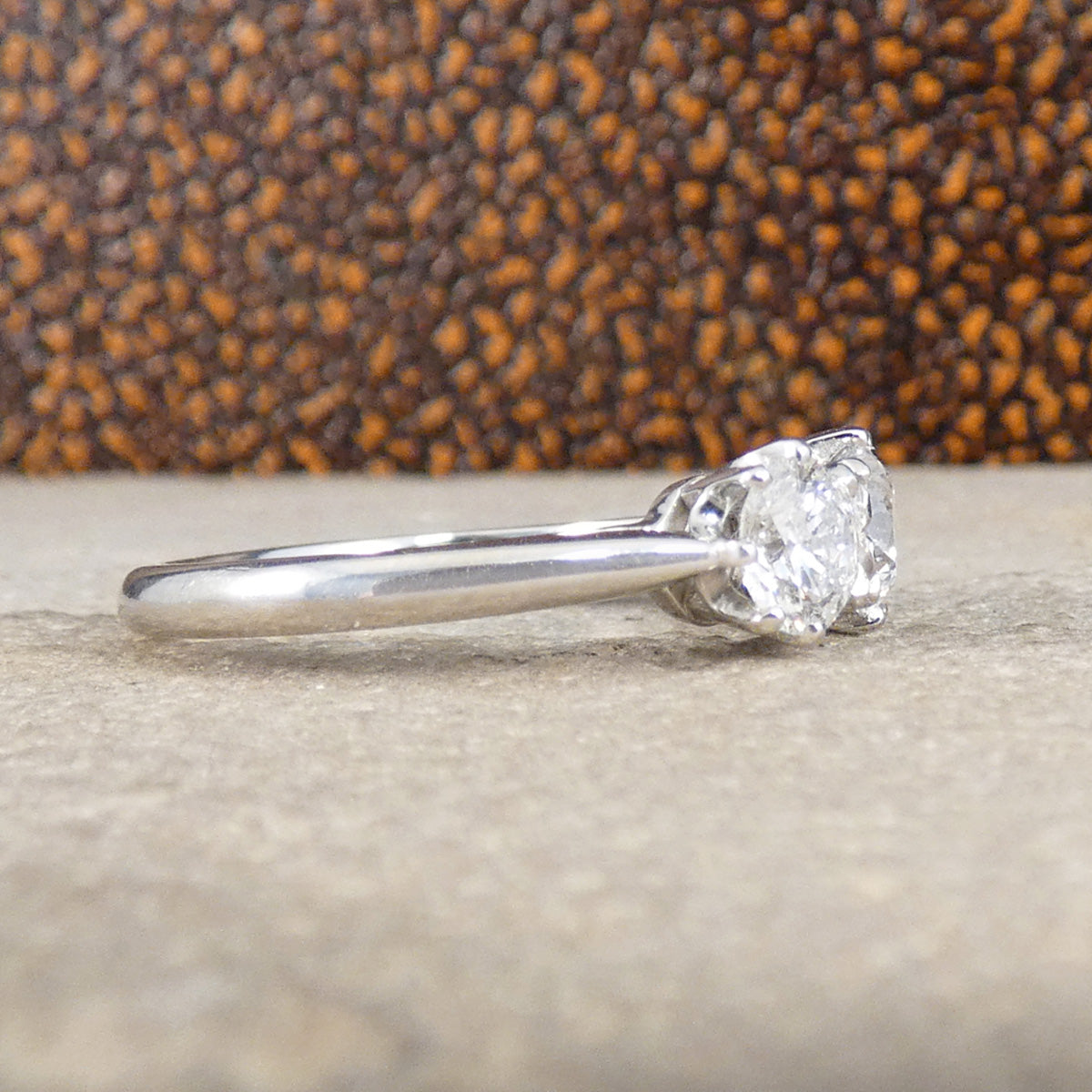 Diamond ring on a textured surface with a brown leather background