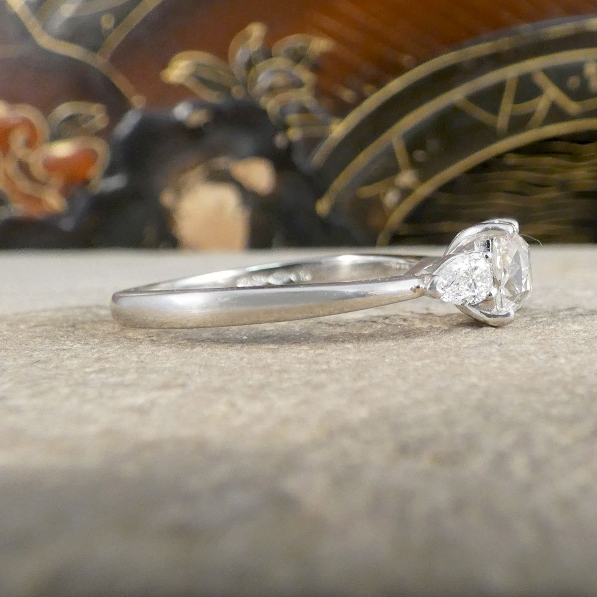 Diamond ring on a textured surface with a decorative background