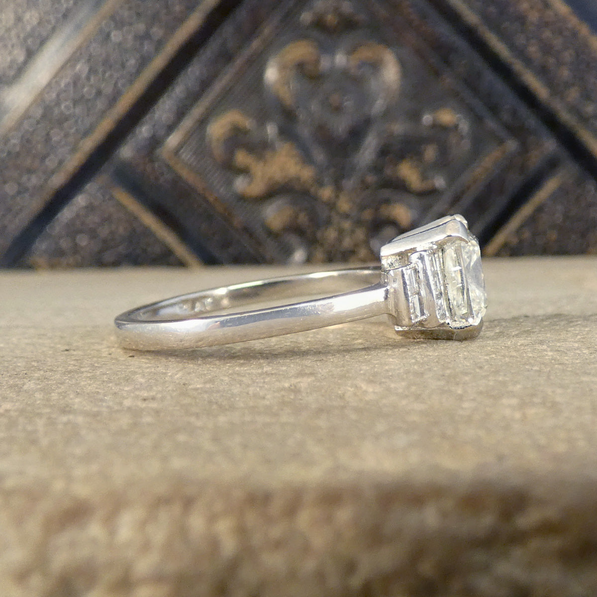 Side view of Art Deco style diamond set ring showing staged diamond set shoulders fully mounted in Platinum.