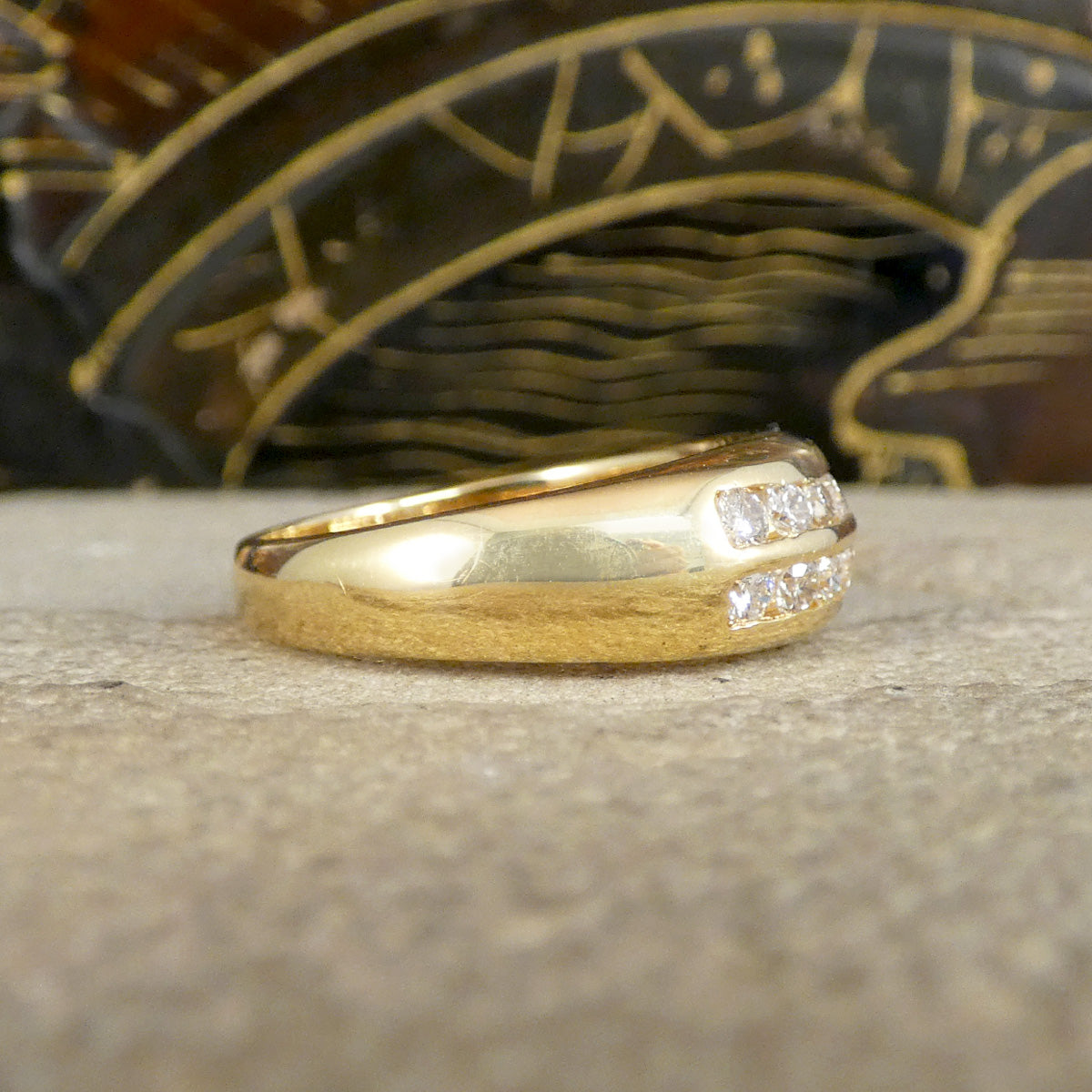 A channel set diamond double row half eternity ring in yellow gold show from the side