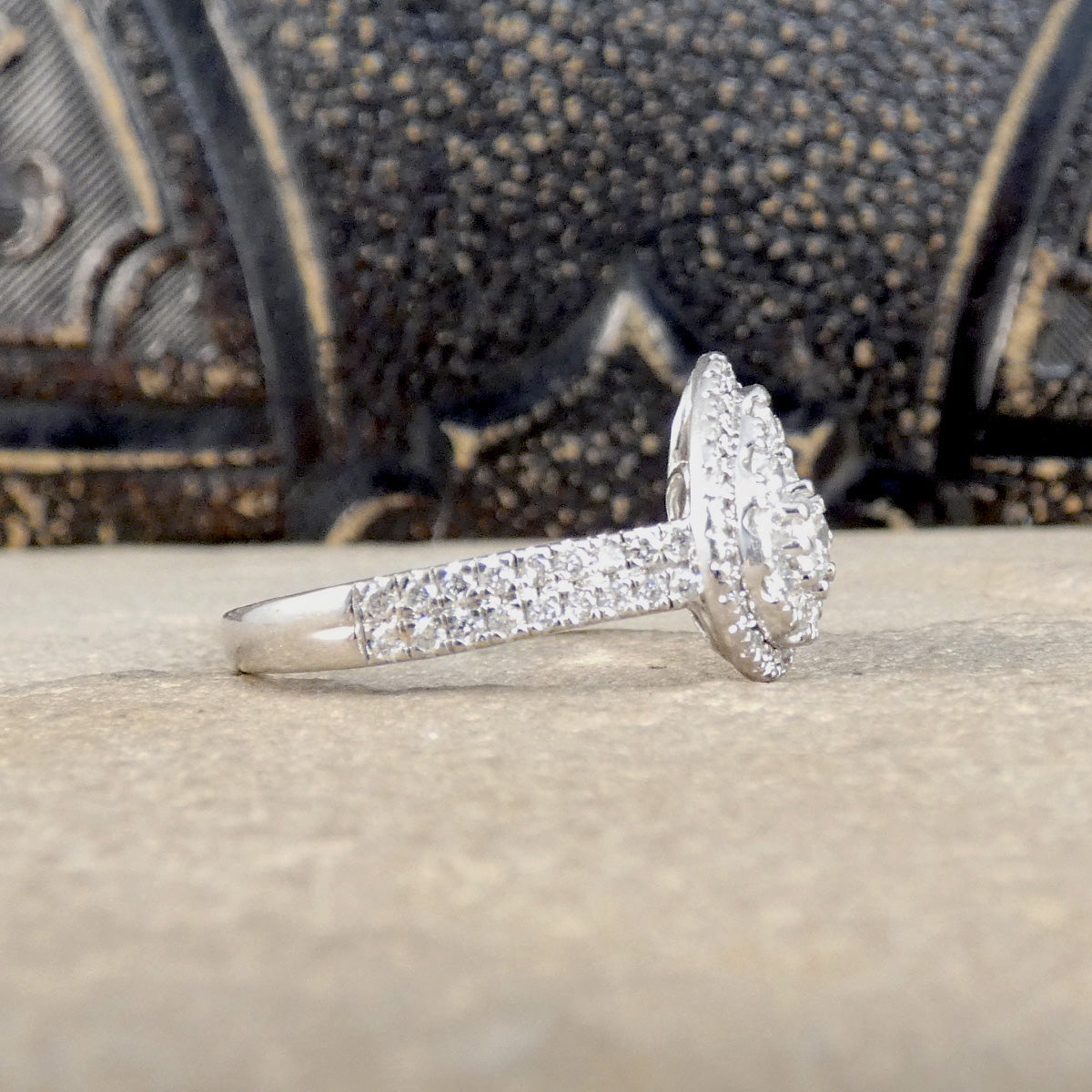 Diamond ring on a textured surface with a decorative background