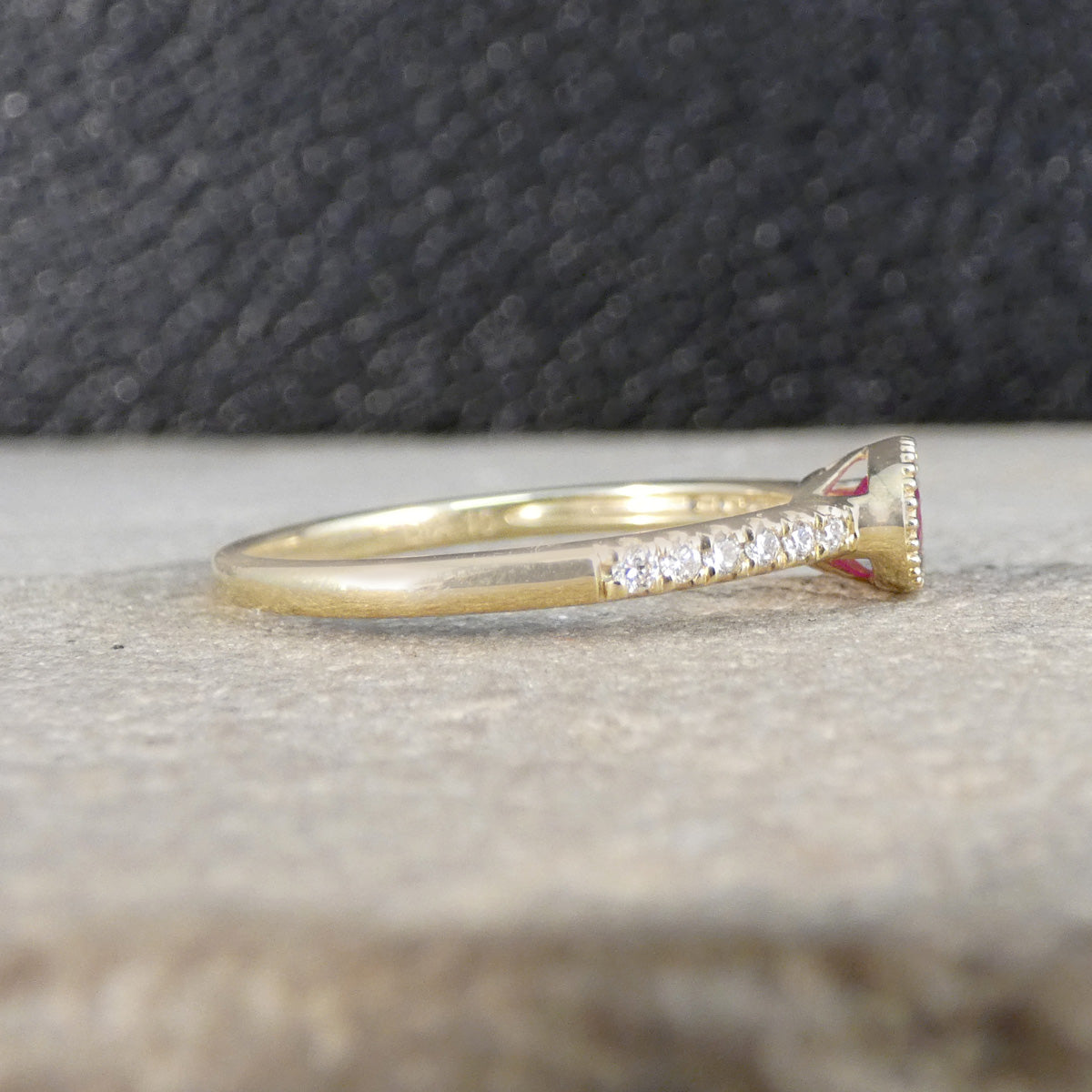 Gold ring with small diamonds on a textured surface