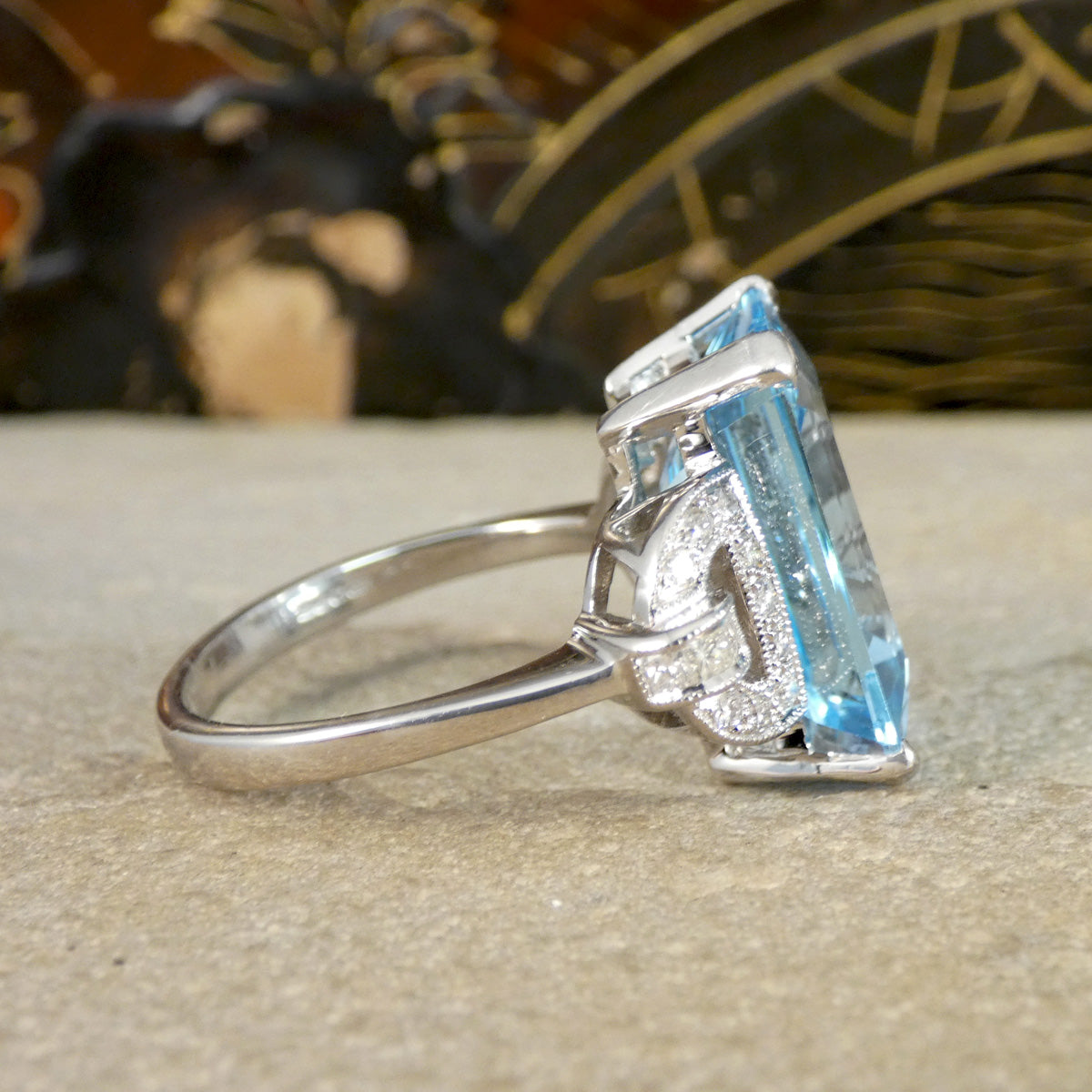 white gold ring with a blue gemstone on a textured surface