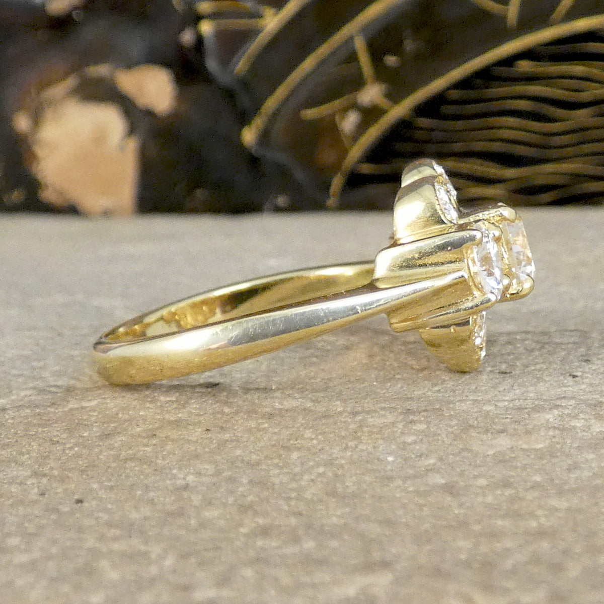 Gold ring with a diamond on a textured surface