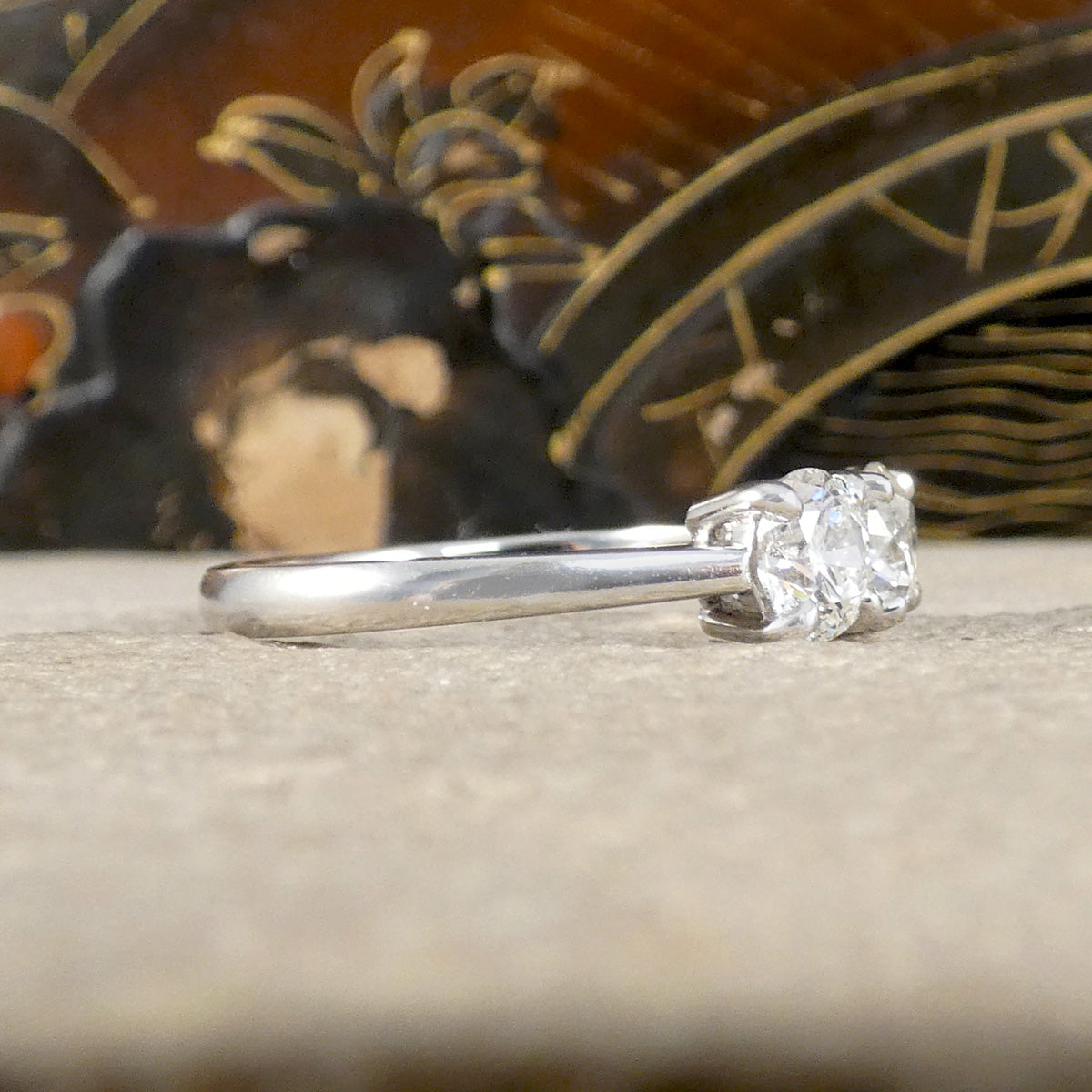 Diamond ring on a wooden surface with a decorative background
