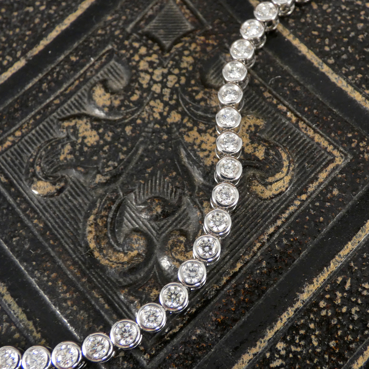 A diamond tennis bracelet in a bezel setting in Platinum