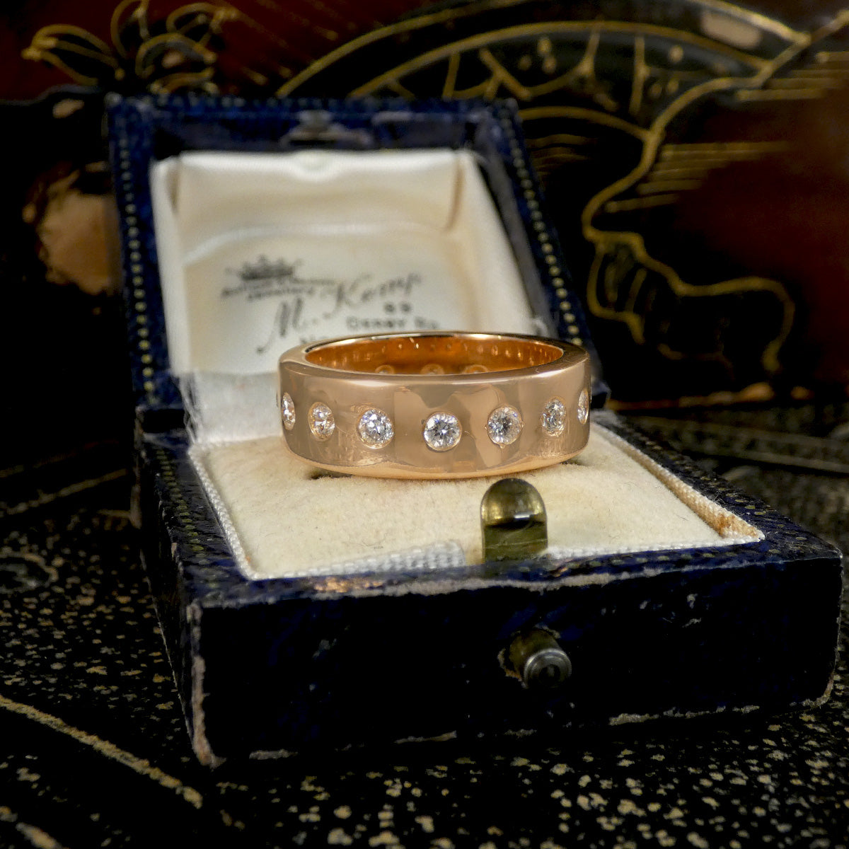 A diamond set band ring shown on a jewellery box.