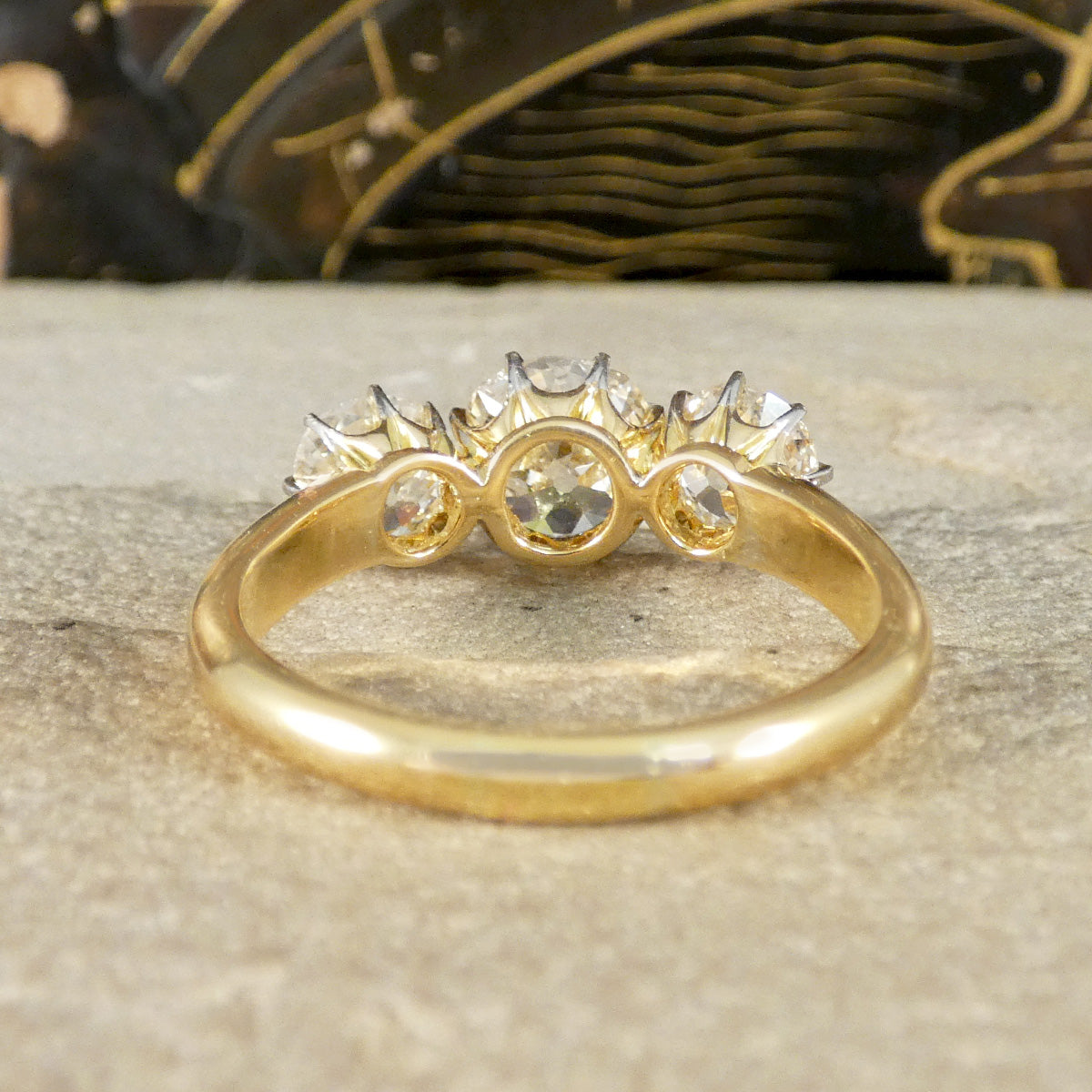 Gold ring with diamonds on a textured surface
