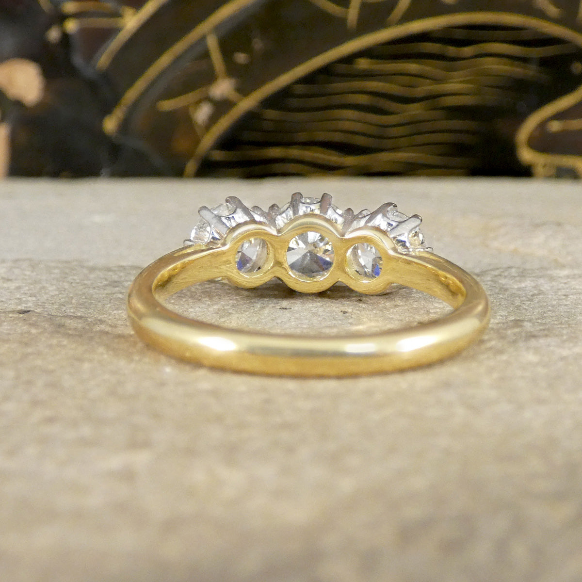 Gold ring with diamonds on a textured surface
