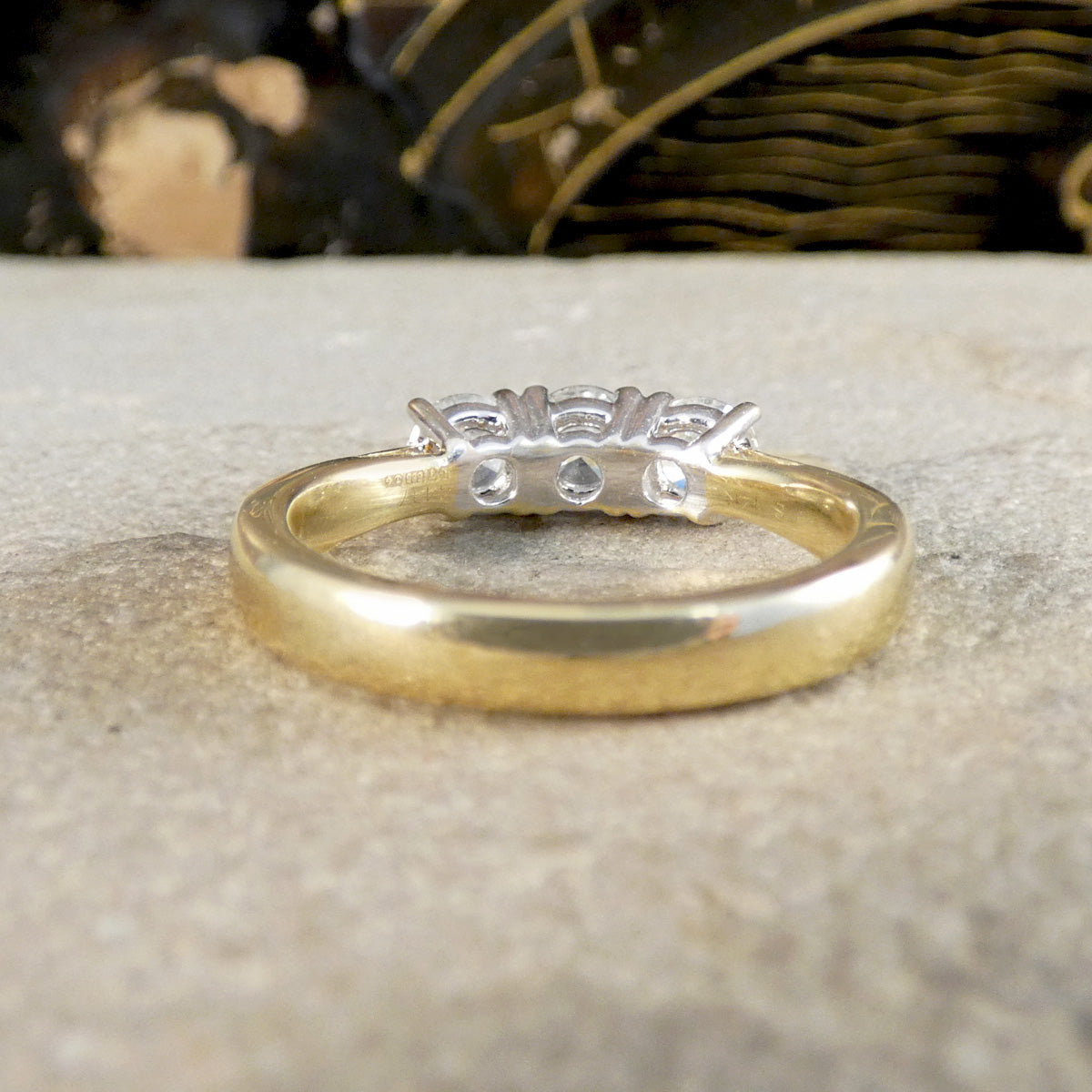 Gold ring with diamond accents on a textured surface