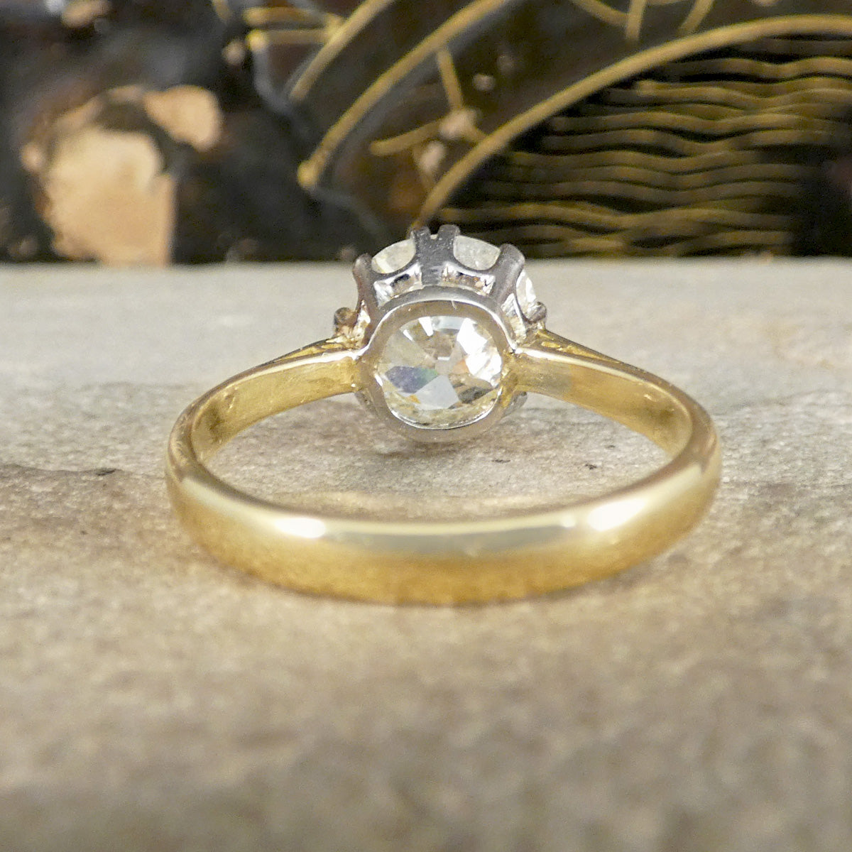 Gold ring with a diamond on a textured surface
