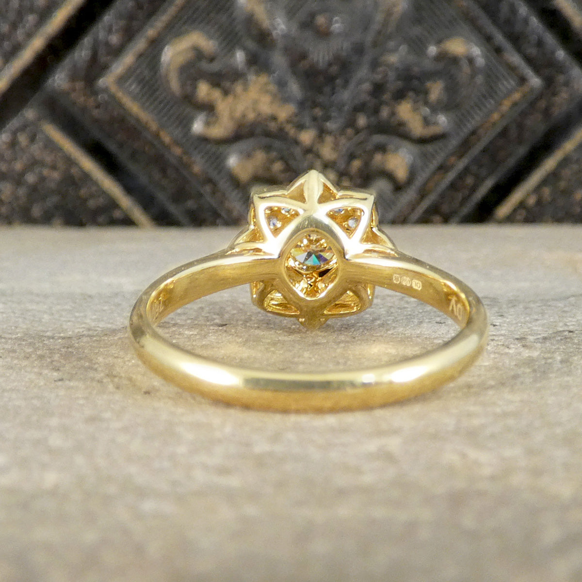 Gold ring with intricate design on a textured surface