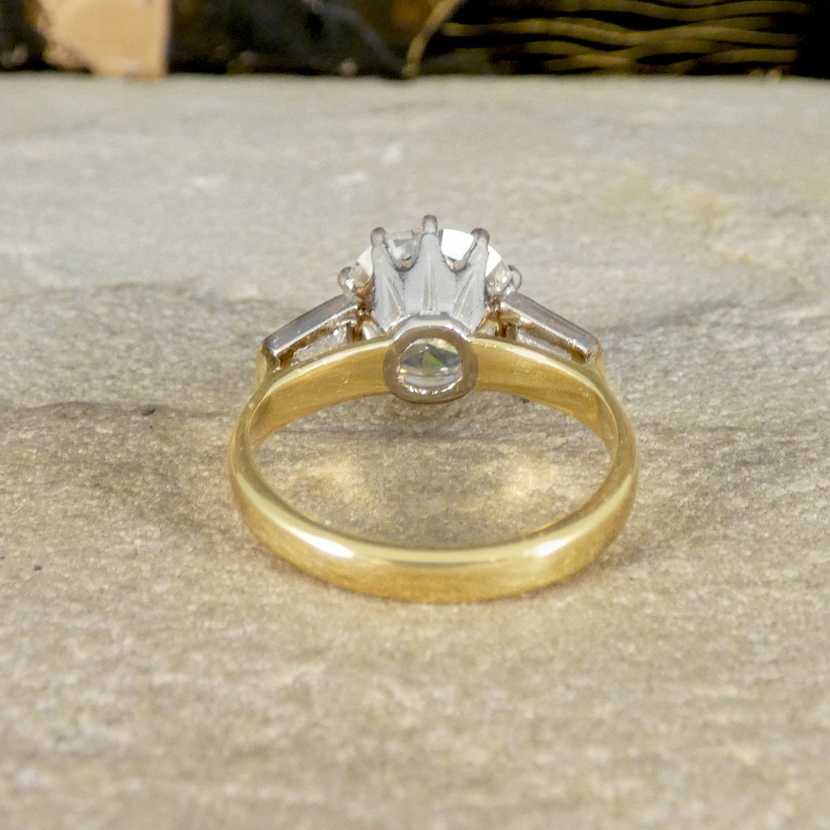 Gold ring with a diamond on a stone surface