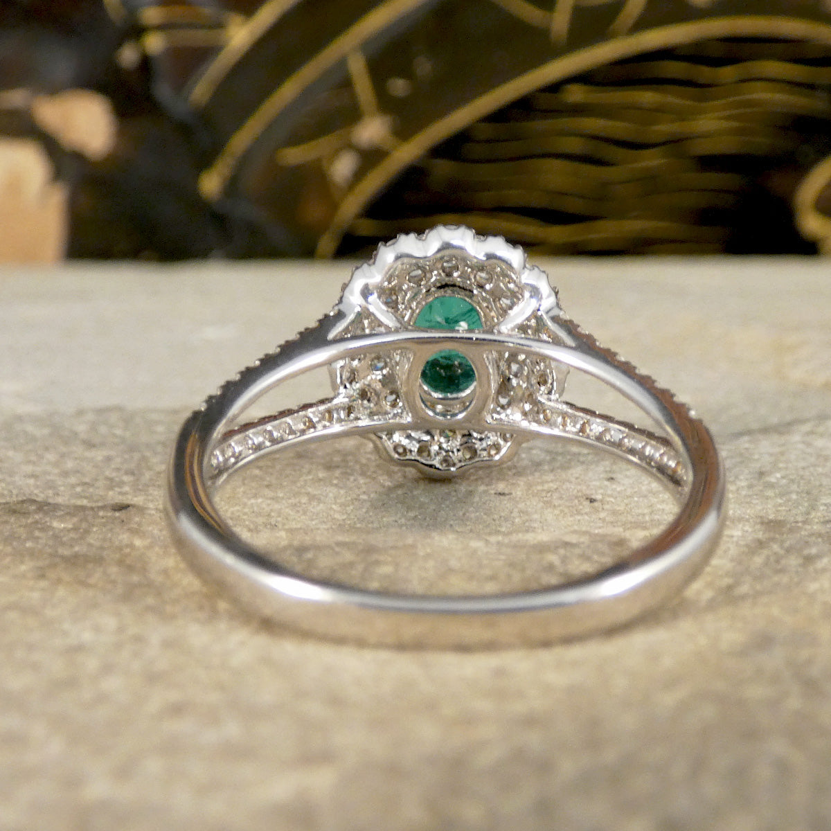 Silver ring with a green gemstone on a wooden surface