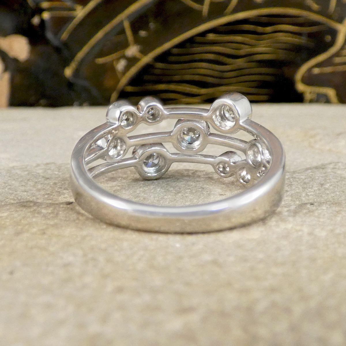 Silver ring with intricate design on a textured surface