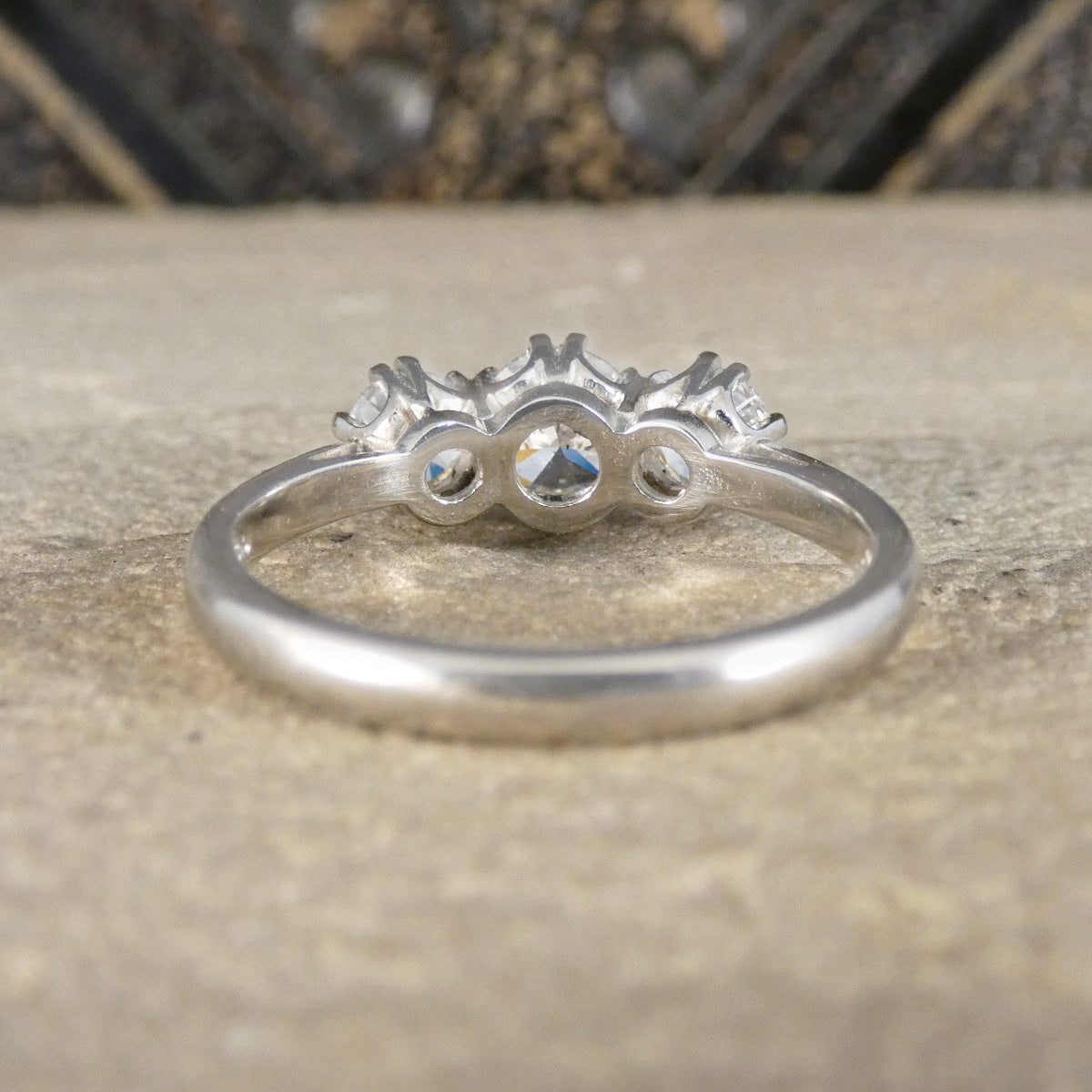 Platinum ring with three diamonds on a textured surface