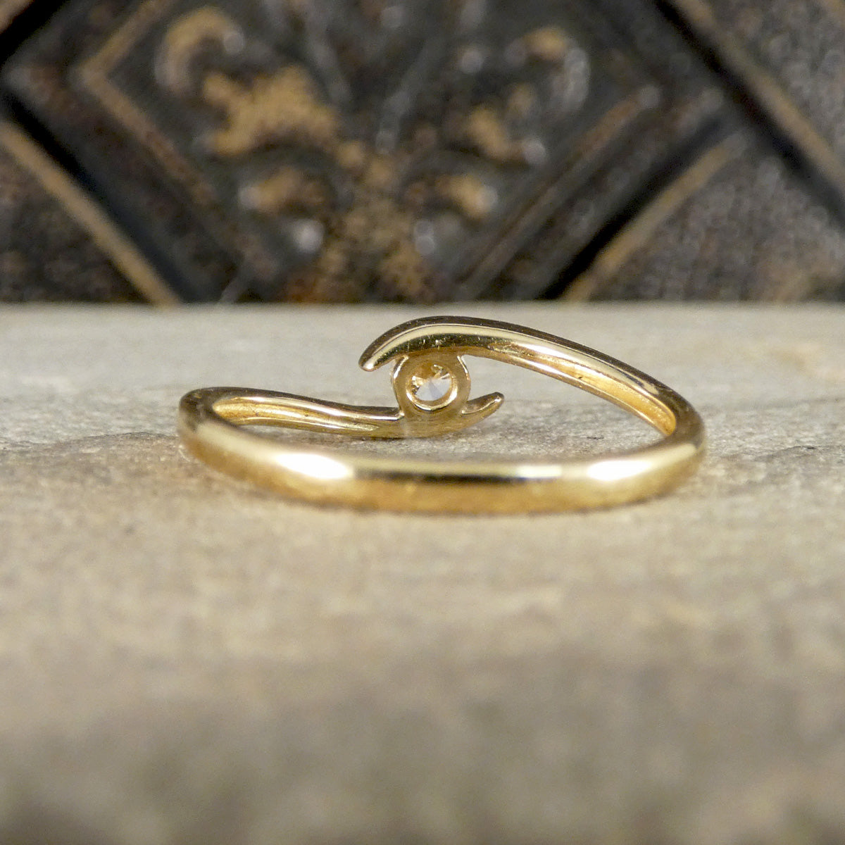 Gold ring with a wave design on a textured surface
