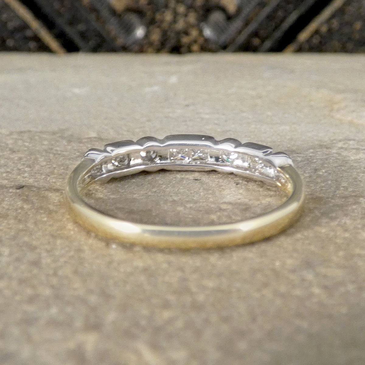 Gold ring with small diamonds on a textured surface