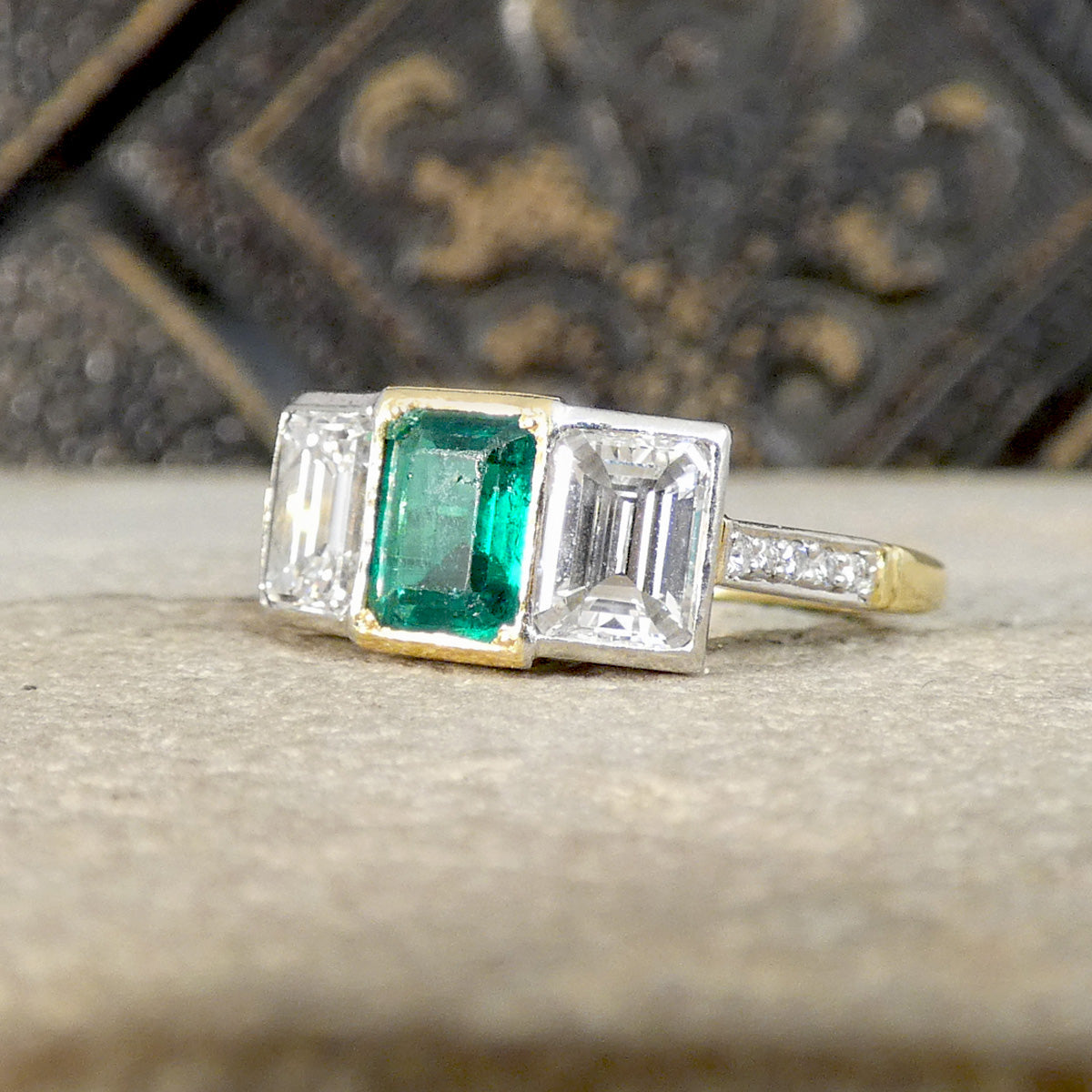 An Emerald and Diamond three stone ring in 18ct white and yellow gold.