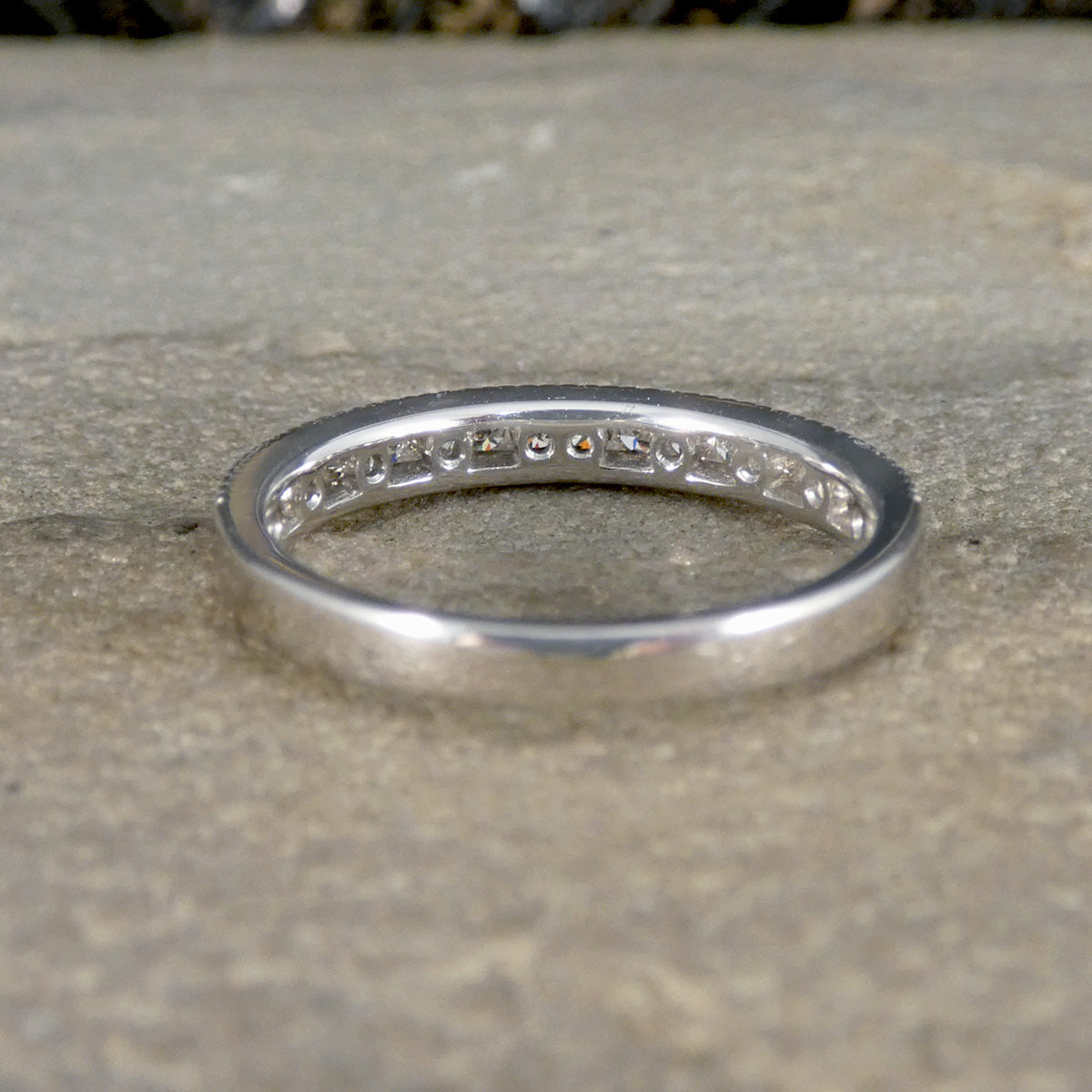 White Gold ring with small stones on a textured surface
