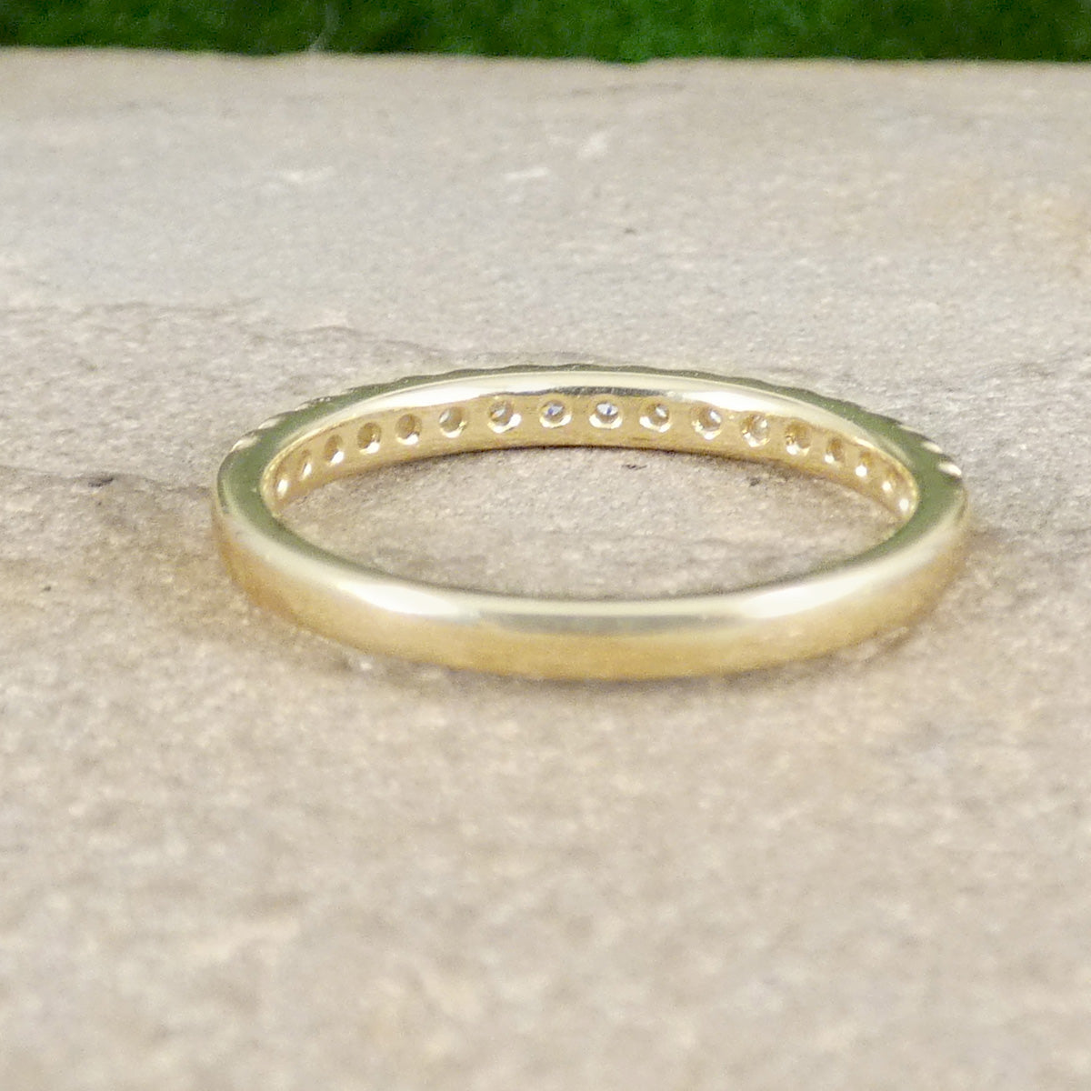 A diamond half eternity ring in yellow gold, perfect stacking ring shown from behind