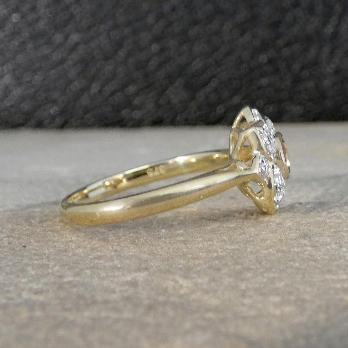 Gold ring with a diamond on a textured surface