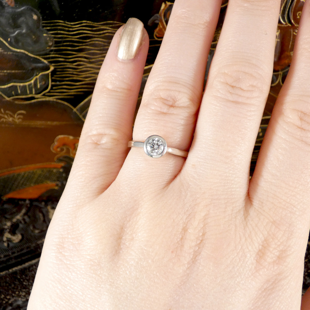 A gorgeous diamond solitaire engagement ring shown worn on the ring finger to see ratio.