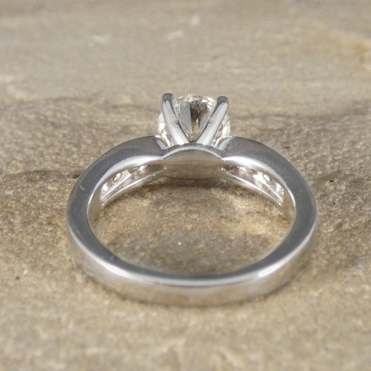 Silver ring with a diamond on a textured surface