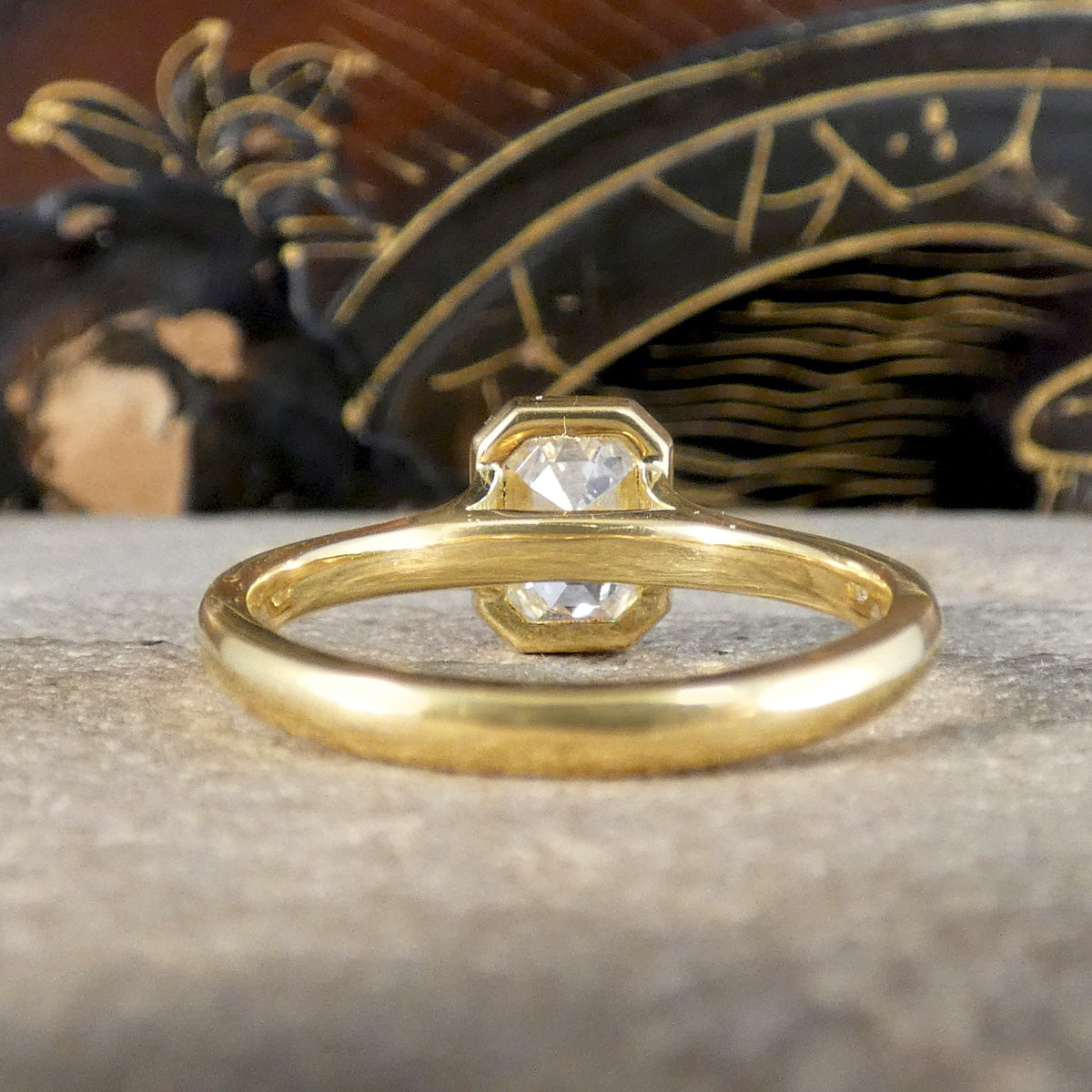 Back view of 1.55ct Emerald Cut Diamond Solitaire in a Bezel Setting in 18ct Yellow Gold, showcasing a clear and bright diamond graded F/VS. Showing open setting and wedfit design.