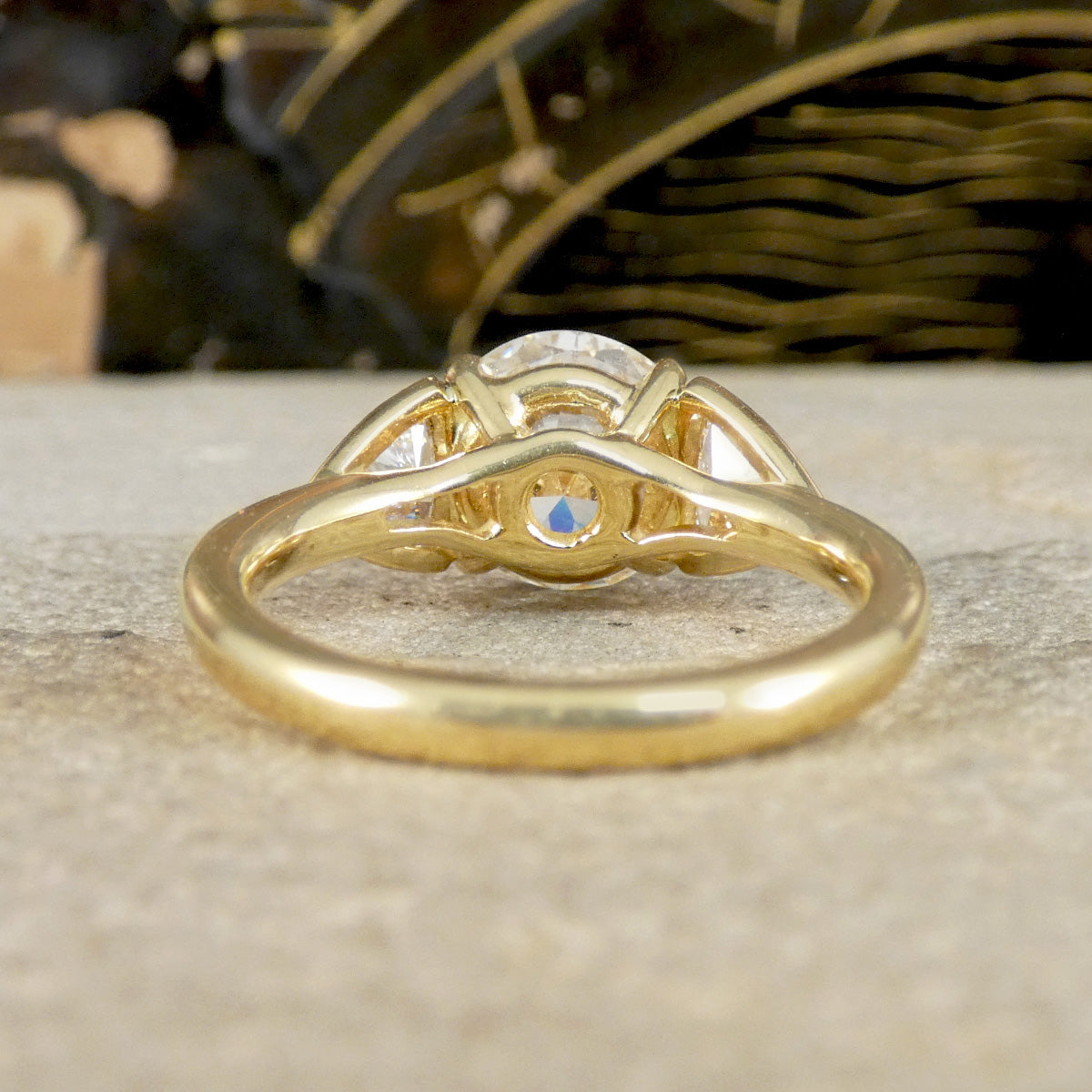 Gold ring with a central gemstone on a textured surface