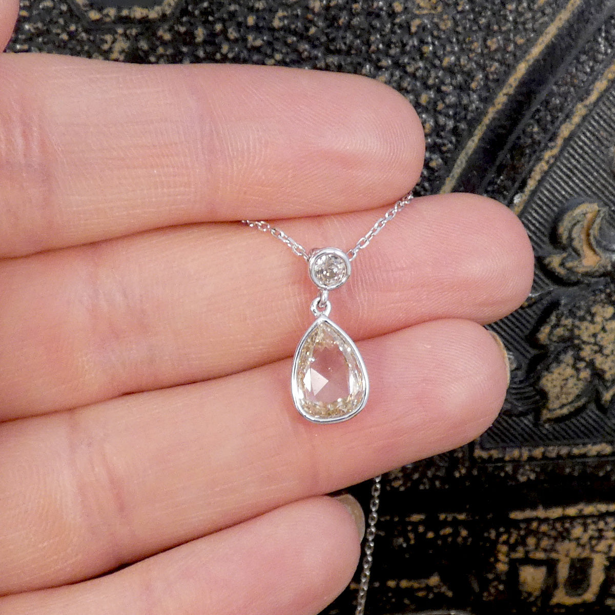 Unique modified rose cut Diamond and brilliant cut drop necklace in 18ct White Gold. Shown held to see the colour and size reference. 