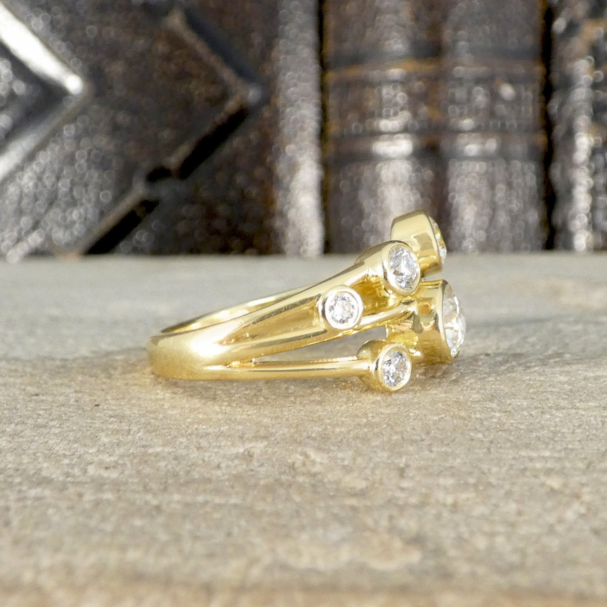 Side view of bubble style ring showing different sized diamonds across three strands.