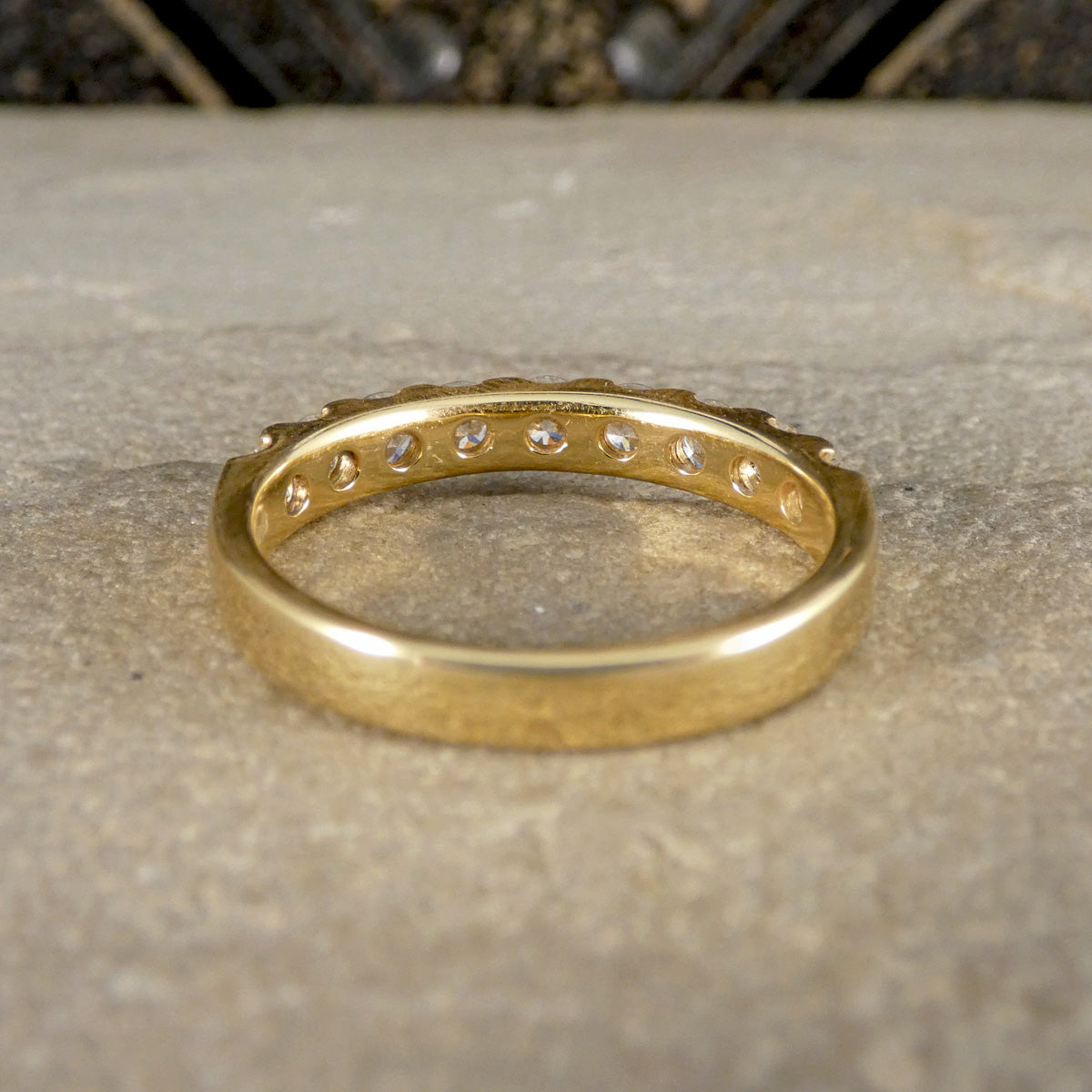 Gold ring with diamonds on a textured surface