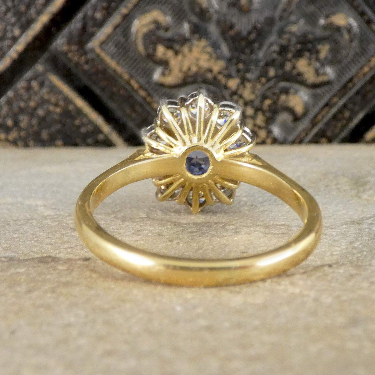Gold ring with a decorative design on a textured surface